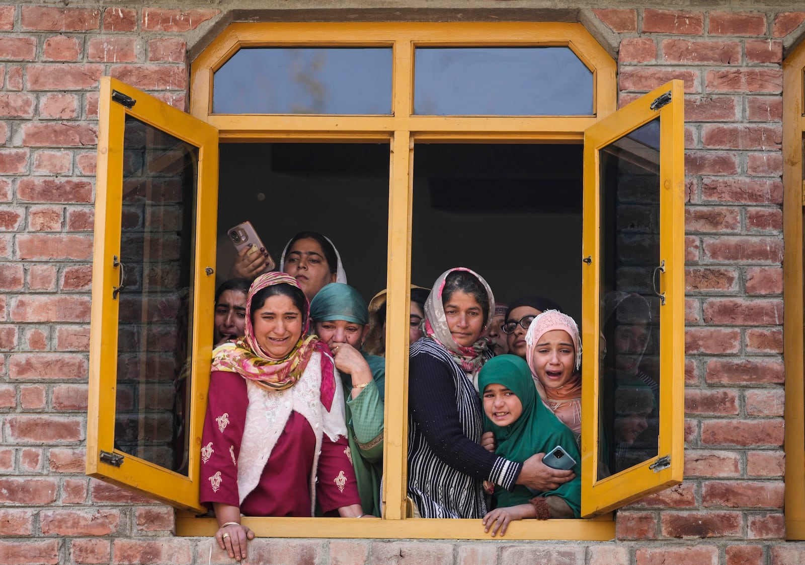 Relatives and neighbors cry as they watch the funeral of Kashmiri doctor Shahnawaz who was among those killed when gunmen fired at people working on a strategic tunnel project in Indian-controlled Kashmir, at Nadigam village, southwest of Srinagar, Monday, Oct. 21, 2024. (AP Photo/Mukhtar Khan)