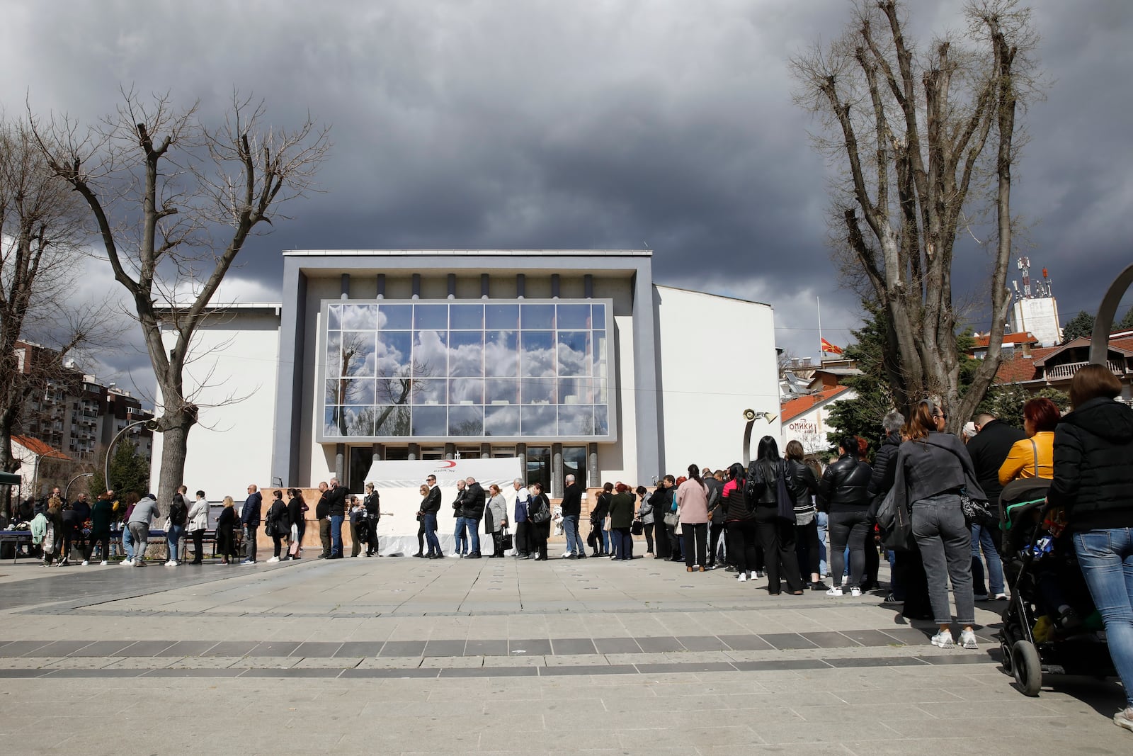 People wait in line to write condolence messages for the victims of a massive nightclub fire in the town of Kocani, North Macedonia, Monday, March 17, 2025. (AP Photo/Boris Grdanoski)