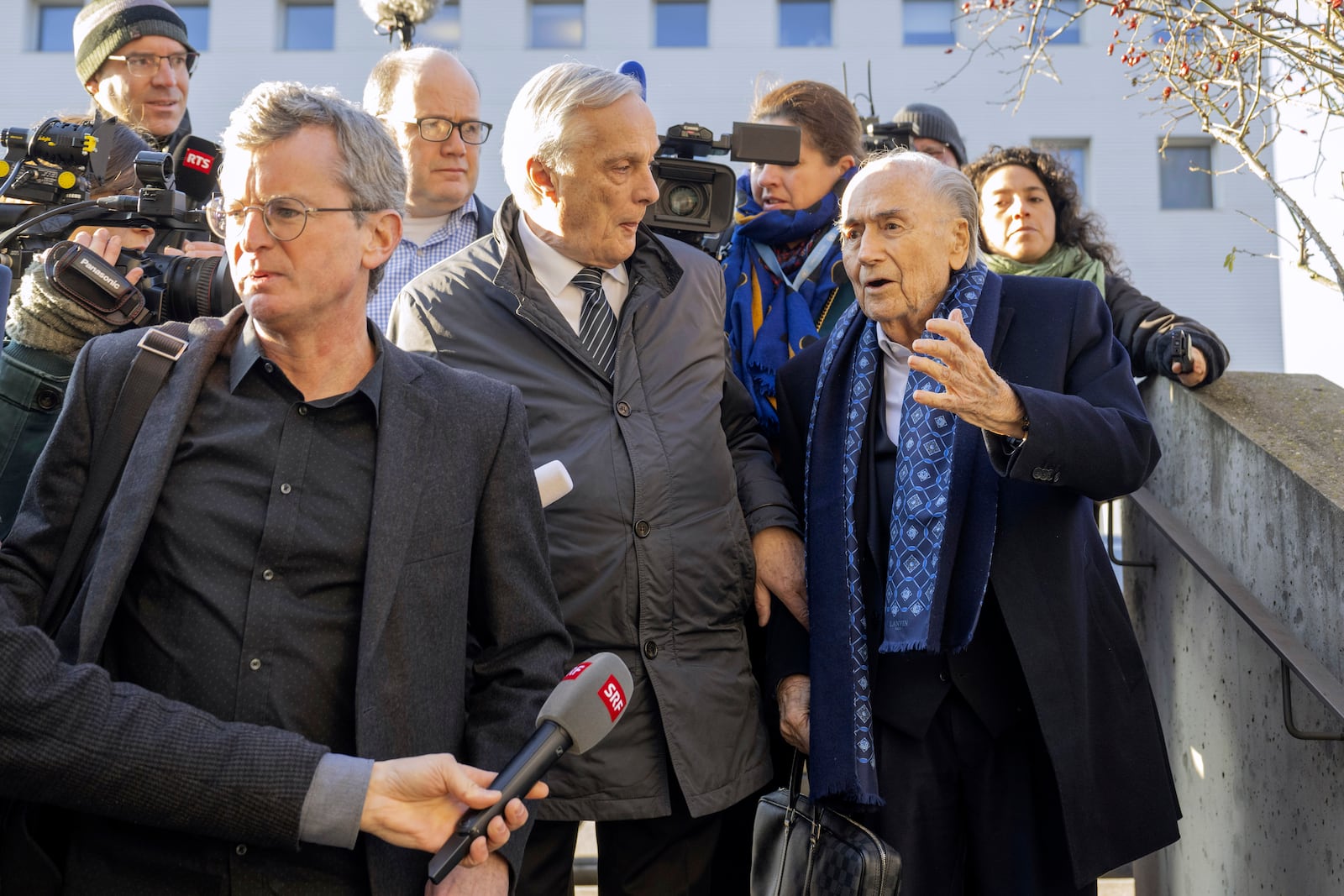 Ex-FIFA President Sepp Blatter, right, arrives in front of the special appeals court in Muttenz, Switzerland, for his retrial on fraud, forgery and misappropriation charges Monday, March 3, 2025. (Urs Flueeler/Keystone via AP)