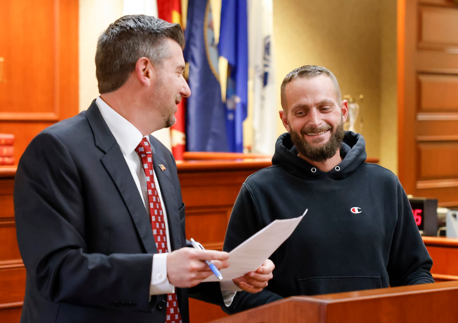 Judge Michael A. Oster Jr., left, signs the final papers for Army veteran David Berryman during Veterans Treatment Court graduation Tuesday, Nov. 15, 2022 in Butler County Common Pleas Court in Hamilton. This class had three graduates for a combined total of 25 graduates since Veterans Treatment Court started in 2017. NICK GRAHAM/STAFF