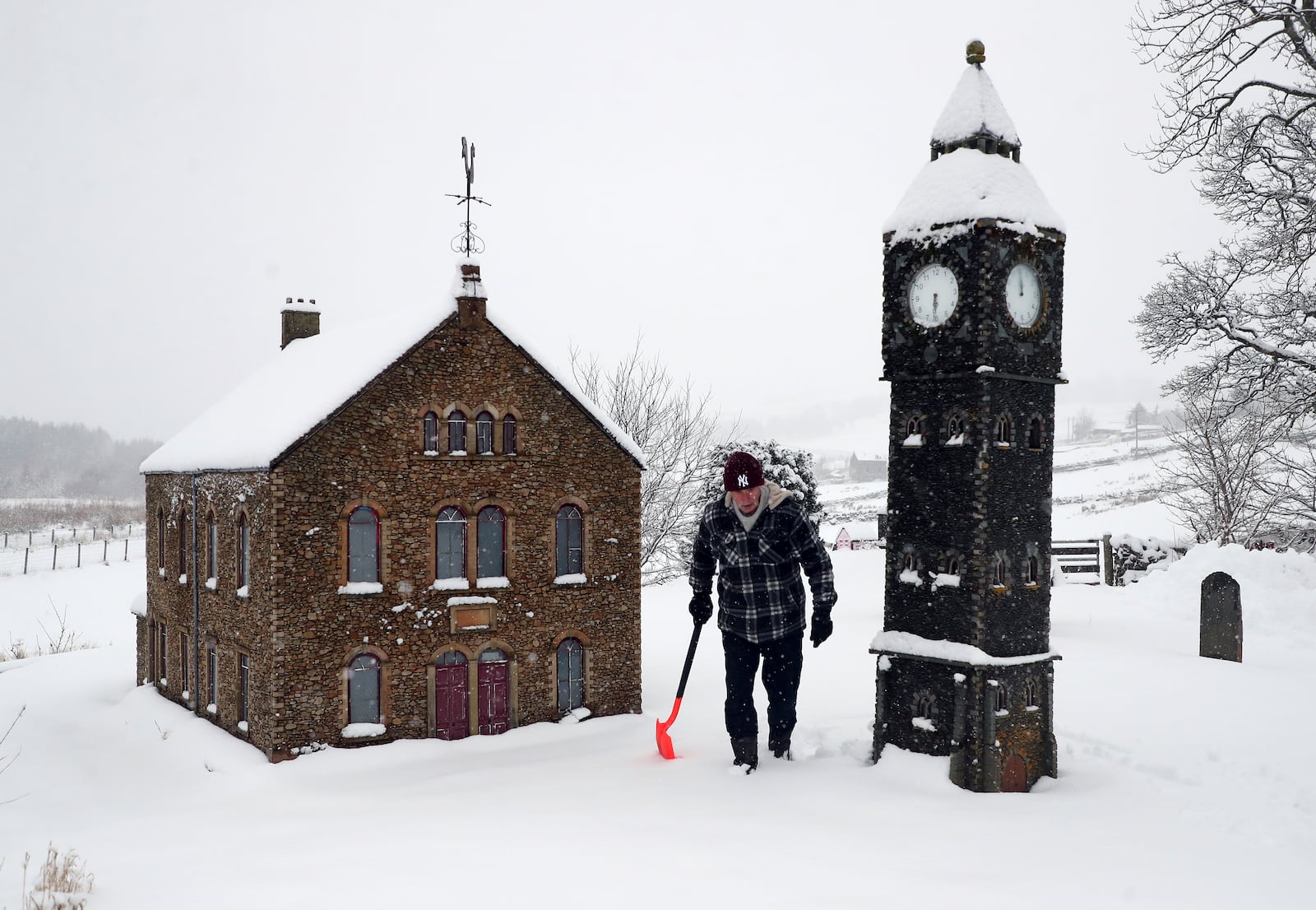 Lowson Robinson is pictured in the heavy snow with his scaled miniature famous landmarks which are located in his garden in Nenthead, England, as the severe weather continues across England, Sunday, Jan. 5, 2025. (AP Photo/Scott Heppell)