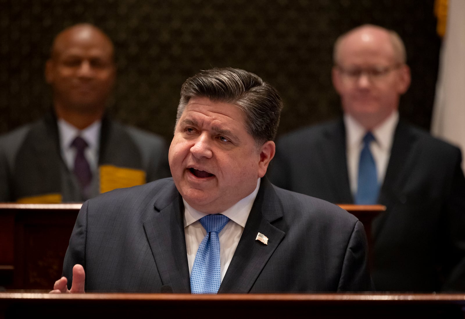 Illinois Gov. JB Pritzker delivers his annual budget address in front of House Speaker Emanuel "Chris" Welch, left, and Senate President Don Harmon, Wednesday, Feb. 19, 2025, at the Illinois State Capitol in Springfield. Ill. (Brian Cassella/Chicago Tribune via AP, Pool)