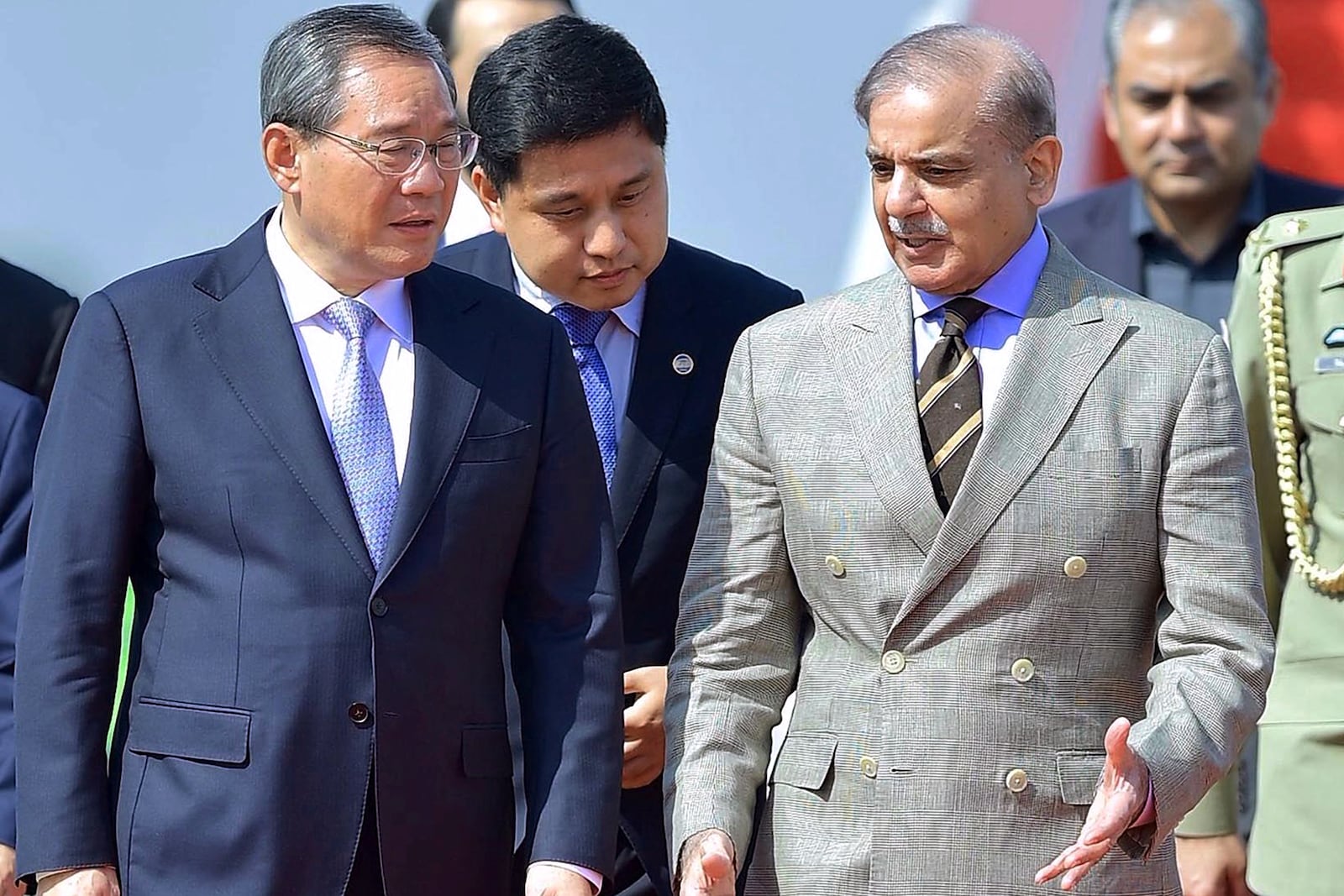 In this photo released by the Press Information Department, China's Premier Li Qiang, left, walks Pakistan's Prime Minister Shehbaz Sharif, upon his arrival at an airbase in Rawalpindi, Pakistan, Monday, Oct. 14, 2024. (Press Information Department via AP)