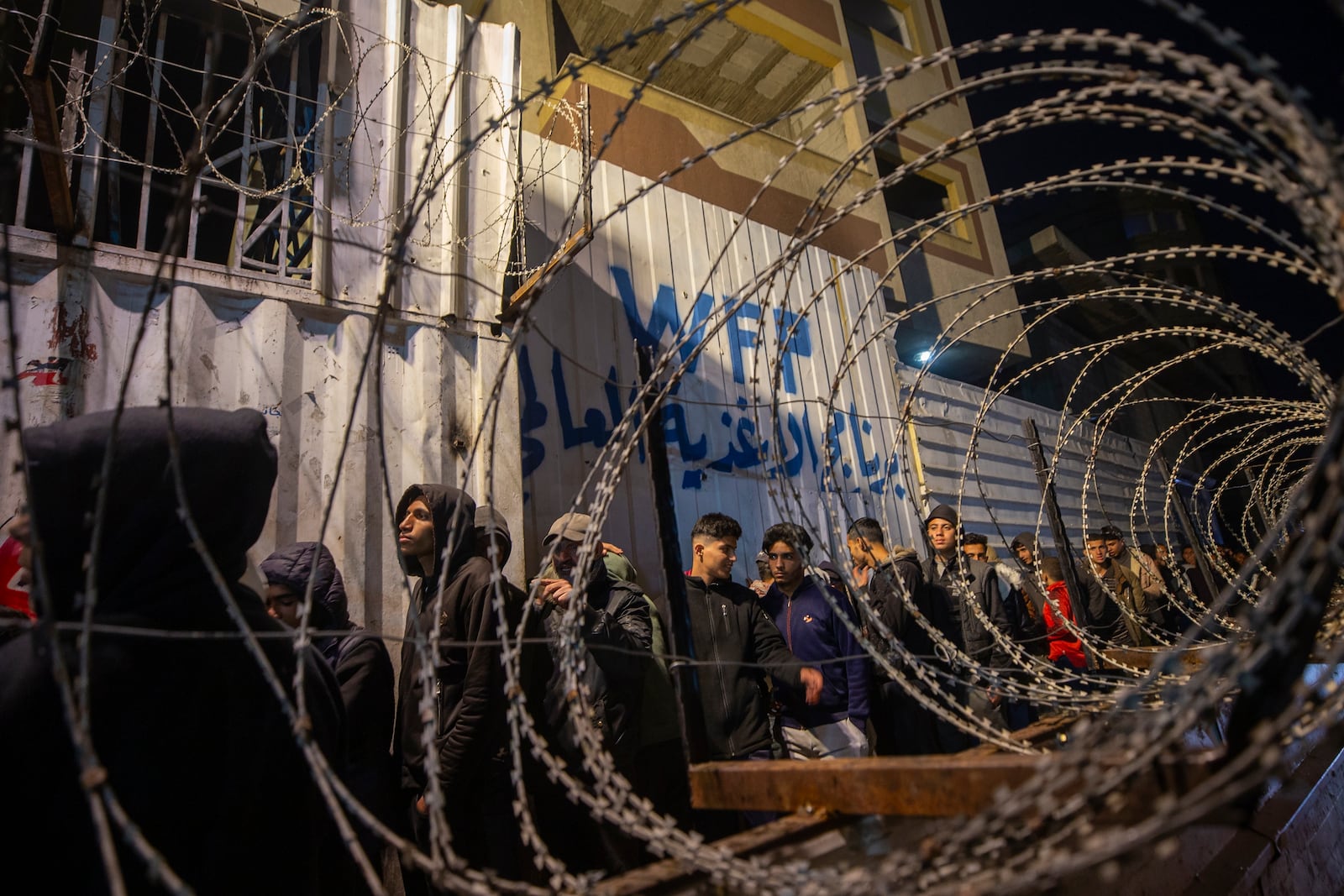 Palestinians wait in line at a World Food Program (WFP) distribution center in Gaza City's Jabalya refugee camp, Thursday, Feb. 6, 2025. (AP Photo/Jehad Alshrafi)