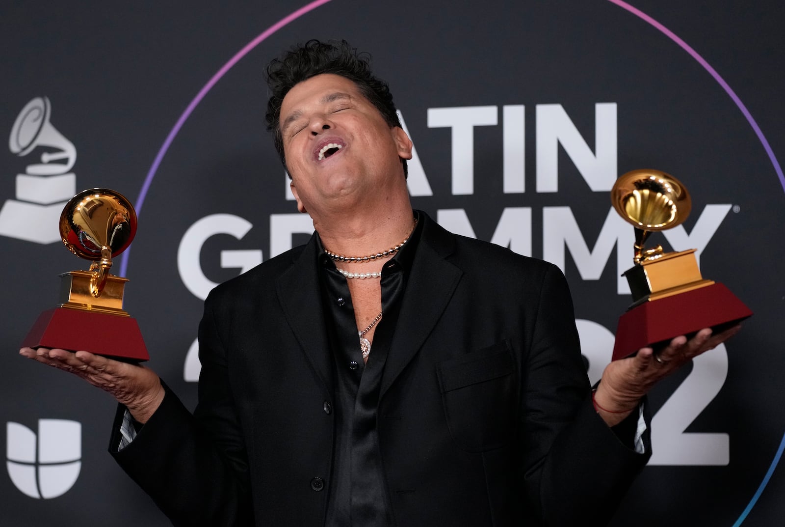 FILE - Carlos Vives poses in the press room with his Latin Grammy gramophone-shaped trophies awarded for best pop/rock and best contemporary tropical album, at the 23rd Annual Latin Grammy Awards in Las Vegas, Nov. 17, 2022. (AP Photo/John Locher, File)