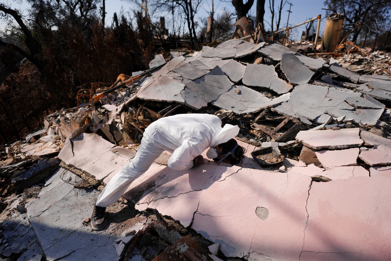 John Borbone searches through his fire-ravaged property after the Palisades Fire in the Pacific Palisades neighborhood of Los Angeles, Tuesday, Jan. 28, 2025. (AP Photo/Jae C. Hong)