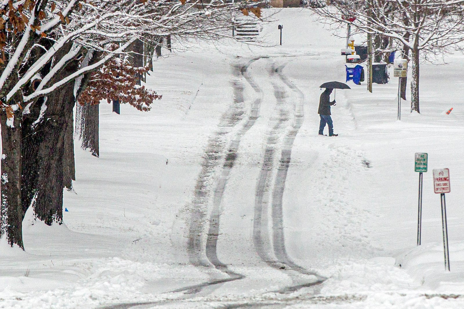 A person crosses West Tennessee Street as snow falls Friday, Jan. 10, 2025, in Florence, Ala. (Dan Busey/The TimesDaily via AP)