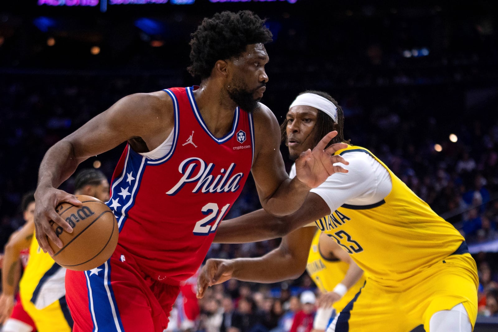 Philadelphia 76ers' Joel Embiid, left, drives to the basket against Indiana Pacers' Myles Turner, right, during the first half of an NBA basketball game, Friday, Dec. 13, 2024, in Philadelphia. (AP Photo/Chris Szagola)