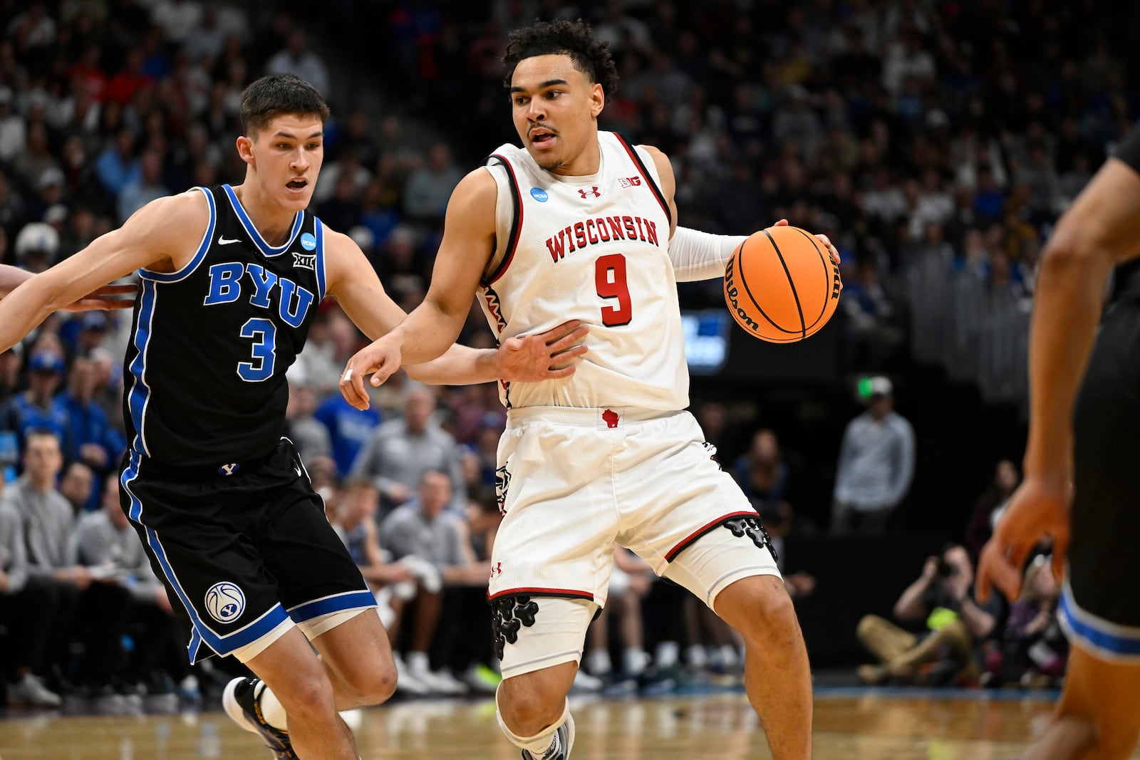 Wisconsin guard John Tonje, right, drives past BYU guard Egor Demin during the second half in the second round of the NCAA college basketball tournament Saturday, March 22, 2025, in Denver. (AP Photo/John Leyba)