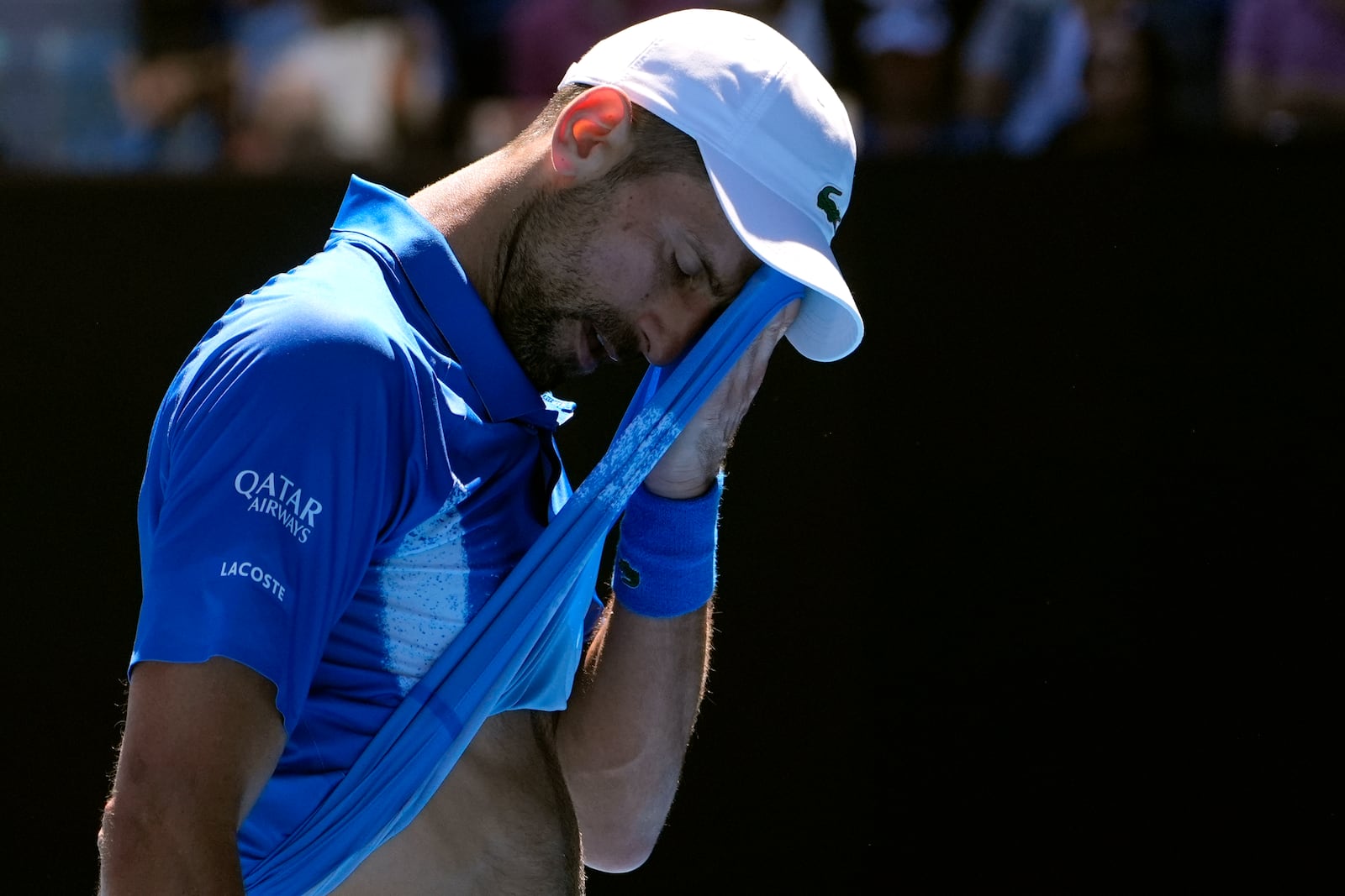 Novak Djokovic of Serbia wipes the sweat from his face during his semifinal match against Alexander Zverev of Germany at the Australian Open tennis championship in Melbourne, Australia, Friday, Jan. 24, 2025. (AP Photo/Asanka Brendon Ratnayake)