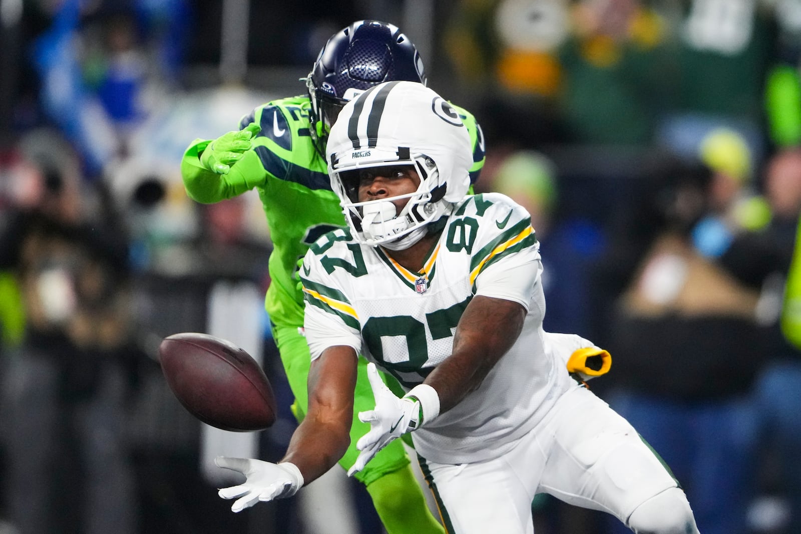 Green Bay Packers' Romeo Doubs catches a touchdown pass in front of Seattle Seahawks' Devon Witherspoon during the second half of an NFL football game Sunday, Dec. 15, 2024, in Seattle. (AP Photo/Lindsey Wasson)