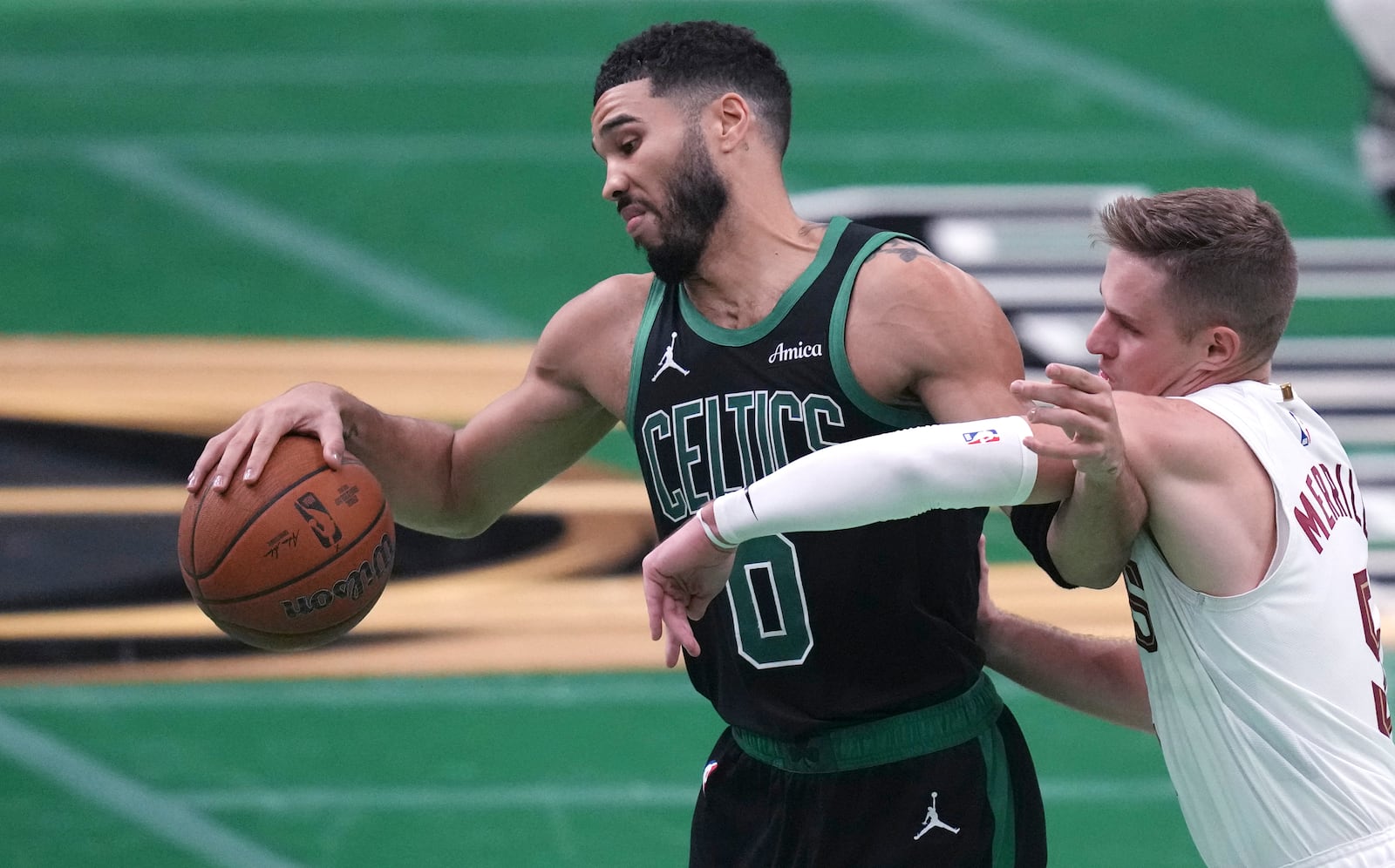 Boston Celtics forward Jayson Tatum (0) holds back Cleveland Cavaliers guard Sam Merrill (5) on a drive to the basket during the second half of an Emirates NBA Cup basketball game, Tuesday, Nov. 19, 2024, in Boston. (AP Photo/Charles Krupa)