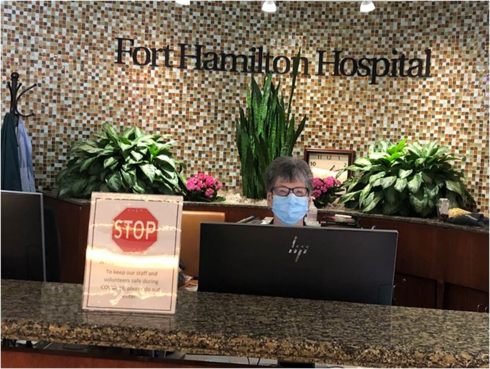 A receptionist on Wednesday worked at newly renamed Kettering Health Hamilton beneath the hospital's old name, Fort Hamilton Hospital. MIKE RUTLEDGE/STAFF