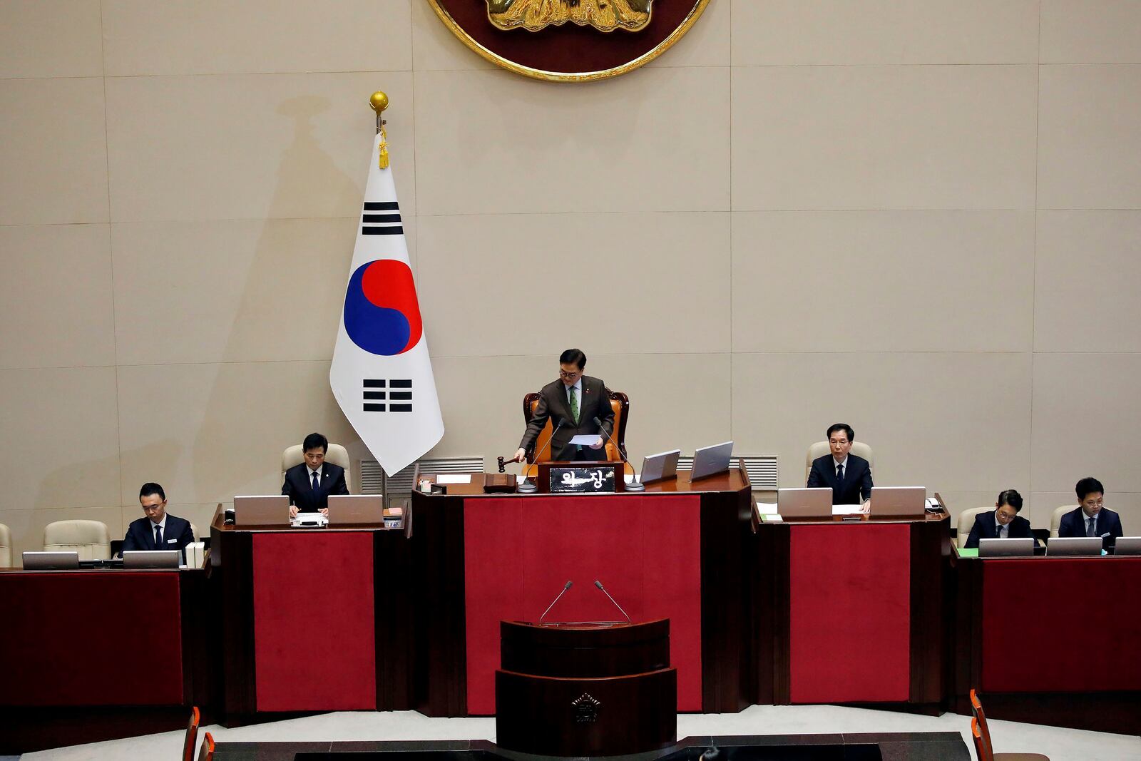 South Korean National Assembly Speaker Woo Won-shik, center, bangs with announcing the president impeachment after the impeachment vote of President Yoon Suk Yeol at the National Assembly in Seoul Saturday, Dec. 14, 2024. (Woohae Cho/Pool Photo via AP)