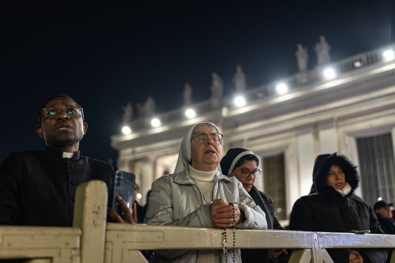 Catholic faithful attend a nightly rosary prayer for the health of Pope Francis in St. Peter's Square at the Vatican, Sunday, March 2, 2025. (AP Photo/Mosa'ab Elshamy)