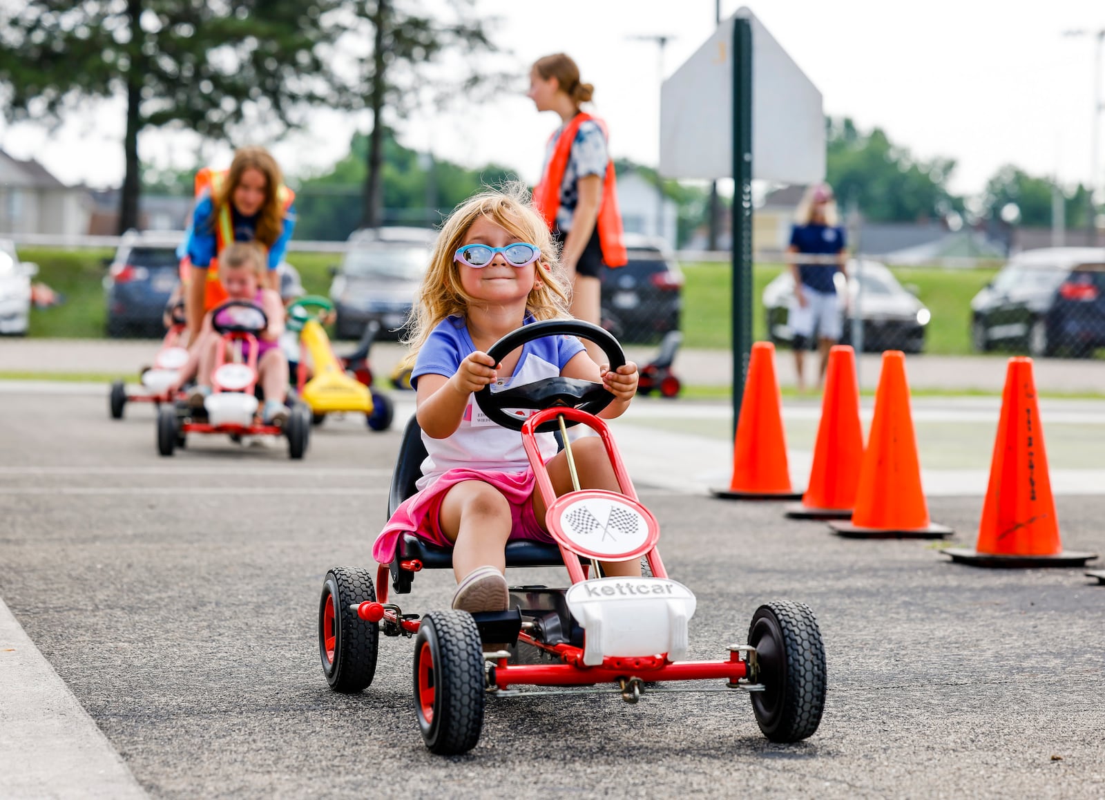 Edith Wiedenmann drives a pedal car around a simulated street course at Safety Town Monday, June 13, 2022 at Office Bob Gentry Park in Hamilton. This is the 50th year of Safety Town in Hamilton. Four and five year old children are instructed in pedestrian, vehicle, bus, gun and fire safety. NICK GRAHAM/STAFF