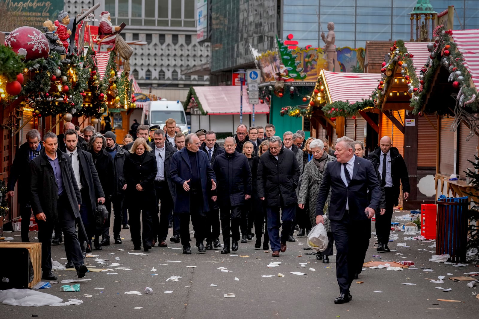 German Chancellor Olaf Scholz, centre, walks over a Christmas Market, where a car drove into a crowd on Friday evening, in Magdeburg, Germany, Saturday, Dec. 21, 2024. (AP Photo/Michael Probst)