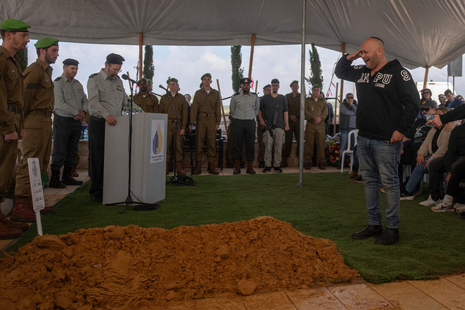 Nir, father of Israeli soldier Sergeant Yahav Maayan who was killed in combat in the Gaza Strip, reacts next to his son's grave during his funeral at a military cemetery in Modiin, Israel, Sunday, Jan. 12, 2025. (AP Photo/Ohad Zwigenberg)