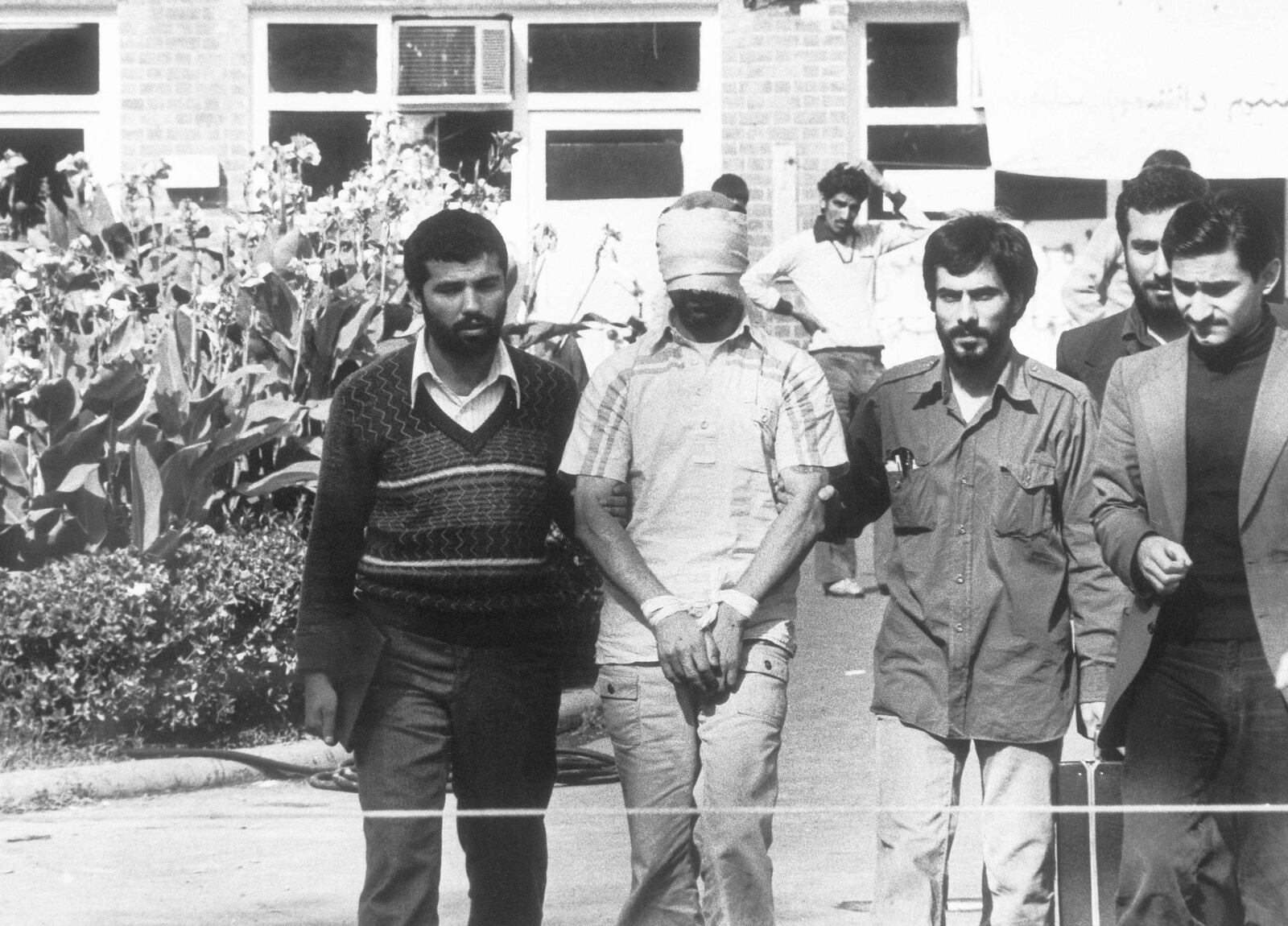 Blindfolded and hands bound, one of the hostages held at the U. S. Embassy in Tehran, Iran is shown to the crowd by Iranian students on Nov. 8, 1979. (AP Photo)