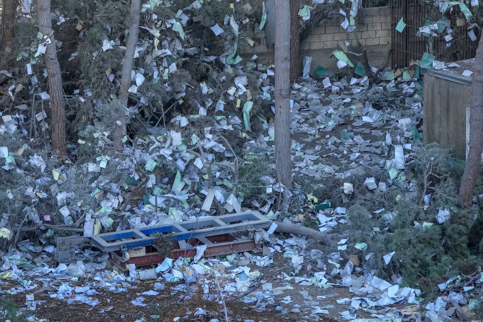 Documents of Hezbollah-run al-Qard al-Hassan are scattered at the site of an Israeli airstrike on Sunday night in Beirut's southern suburb, Lebanon, Monday, Oct. 21, 2024. (AP Photo/Hassan Ammar)