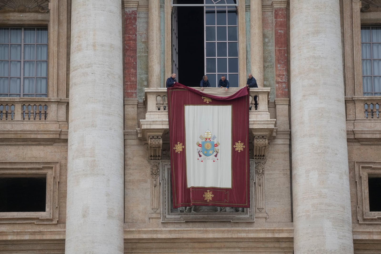 A tapestry is prepared for a mass celebrated by Cardinal Michael Czerny, prefect of the Dicastery for Promoting Integral Human Development, and delegate of Pope Francis, for the members of the world of volunteers in St. Peter's Square at The Vatican, Sunday, March 9, 2025. (AP Photo/Gregorio Borgia)