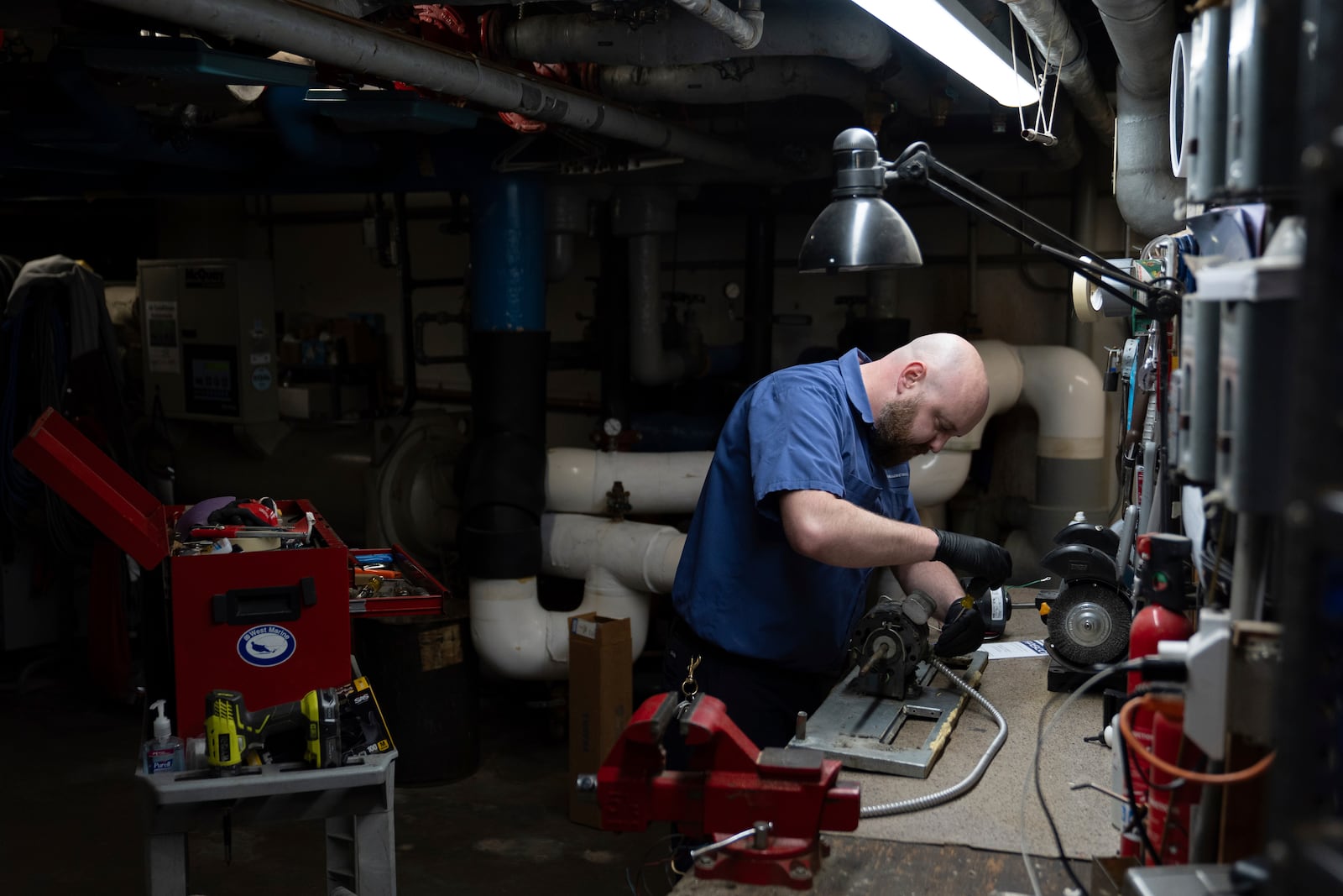 James Richardson works on a heating and cooling unit in the broiler room at Smith Tower Apartments in Vancouver, Wash., on Monday, March 10, 2025. (AP Photo/Jenny Kane)