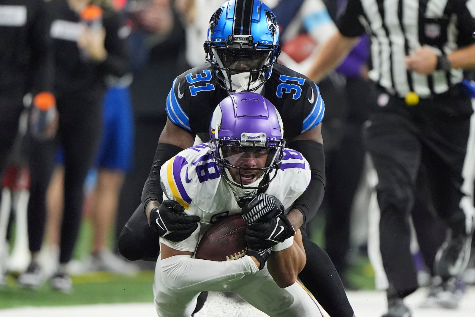 Minnesota Vikings wide receiver Justin Jefferson (18) is hit by Detroit Lions safety Kerby Joseph (31) as he makes a catch during the second half of an NFL football game Sunday, Jan. 5, 2025, in Detroit. (AP Photo/Charlie Riedel)