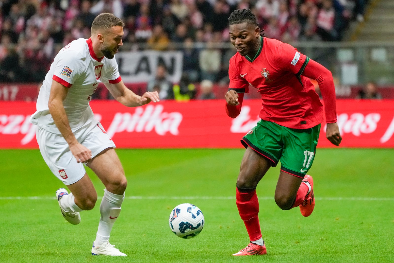 Poland's Sebastian Walukiewicz, left, and Portugal's Rafael Leao vie for the ball during the UEFA Nations League soccer match between Poland and Portugal at Narodowy stadium in Warsaw, Poland, Saturday, Oct. 12, 2024. (AP Photo/Czarek Sokolowski)