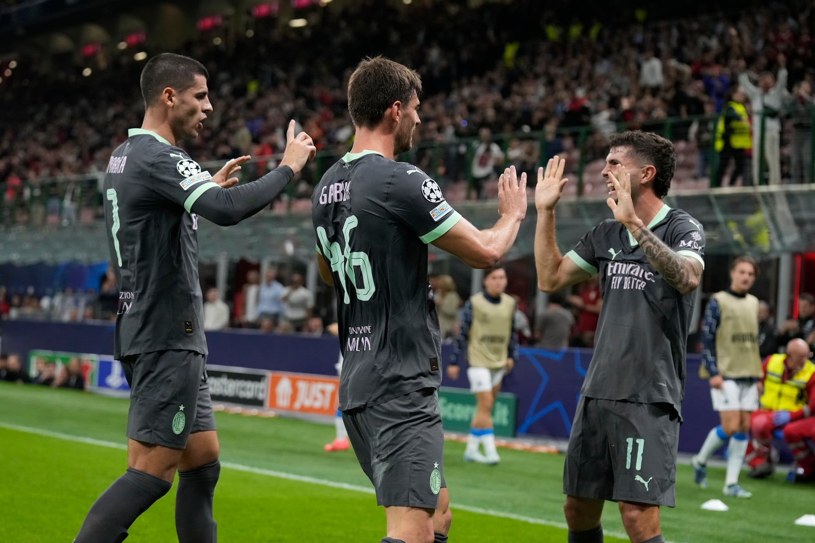 AC Milan's Christian Pulisic, right, celebrates with teammates after scoring his side's first goal during the Champions League opening phase soccer match between AC Milan and Club Brugge at the San Siro stadium in Milan, Italy, Tuesday, Oct. 22, 2024. (AP Photo/Antonio Calani)