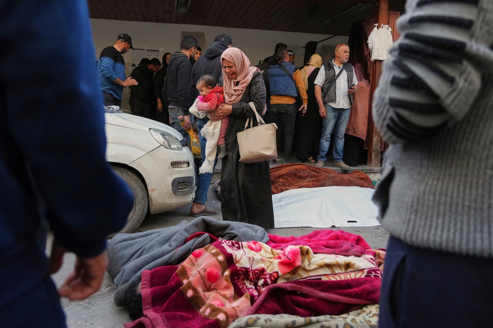 A woman reacts as she stands over the bodies of people killed during overnight Israeli army airstrikes across the Gaza Strip, at the Al-Ahli hospital in Gaza City, Tuesday, March 18, 2025. (AP Photo/Jehad Alshrafi)