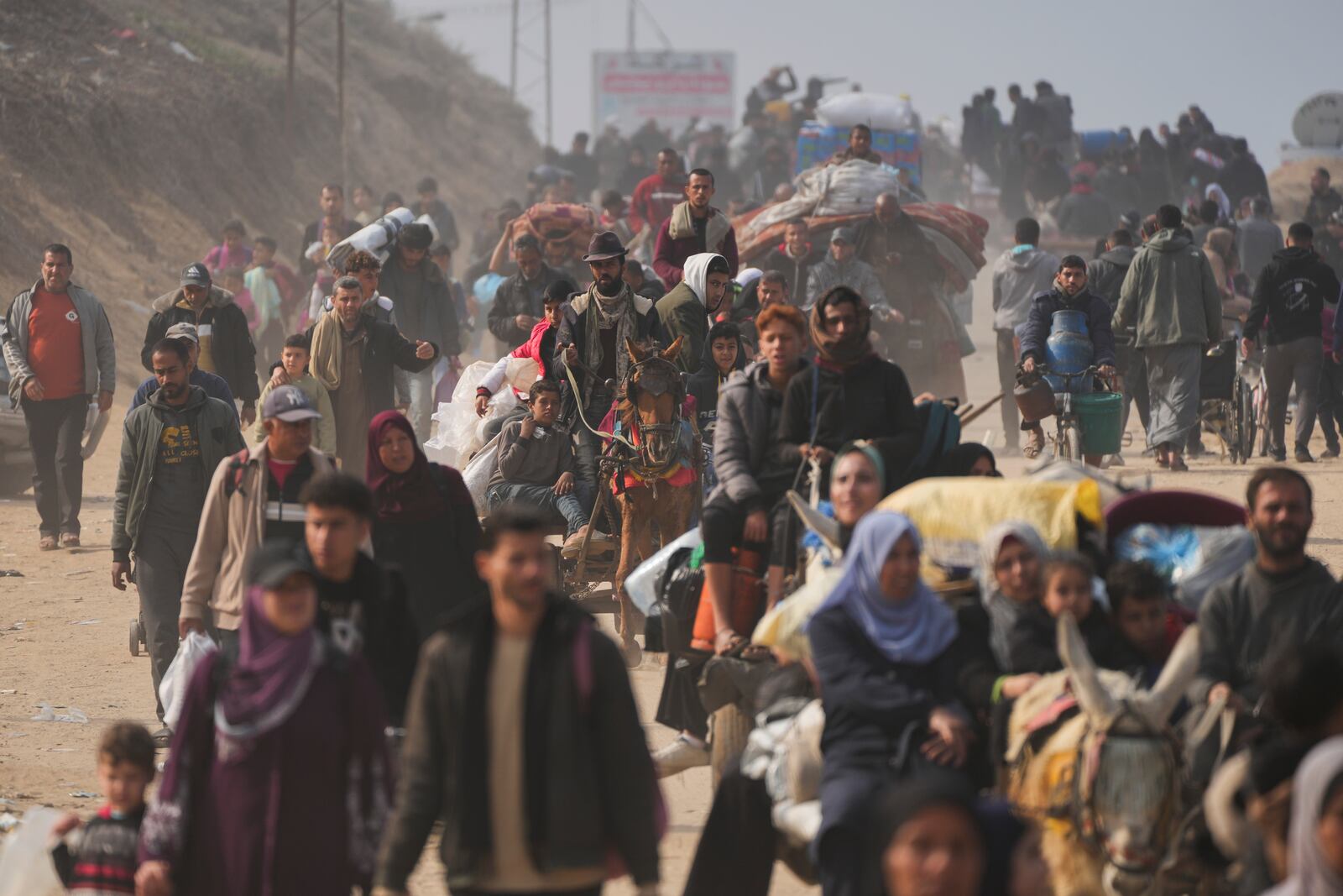 Displaced Palestinians walk on a road in central Gaza to return to their homes in the northern Gaza Strip, following the Israel-Hamas ceasefire deal, Friday, Jan. 31, 2025. (AP Photo/Abdel Kareem Hana)