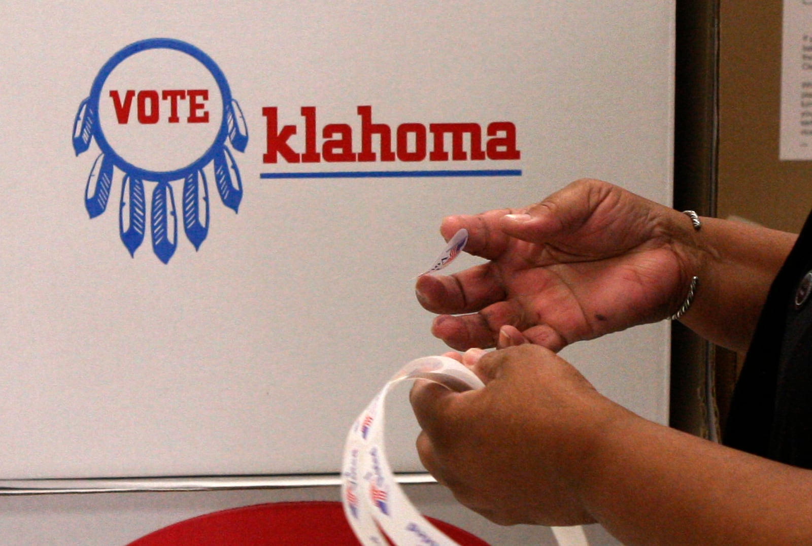 FILE - Election board inspector Pat Cook readies "I Voted" stickers for voters during early voting in Oklahoma City, Friday, Oct. 29, 2010. (AP Photo/Sue Ogrocki, File)