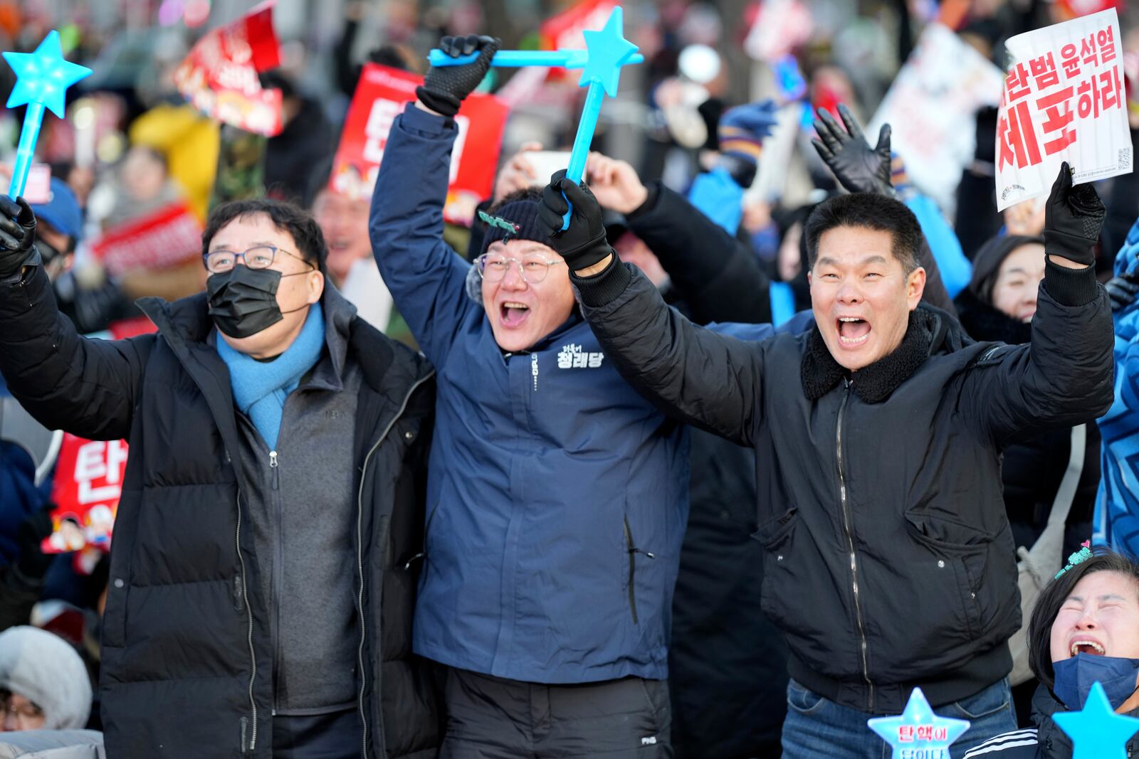 People celebrate after hearing the news of South Korean President Yoon Suk Yeol's impeachment outside the National Assembly in Seoul, South Korea, Saturday, Dec. 14, 2024. The letters read "Arrest Yoon Suk Yeol." (AP Photo/Lee Jin-man)