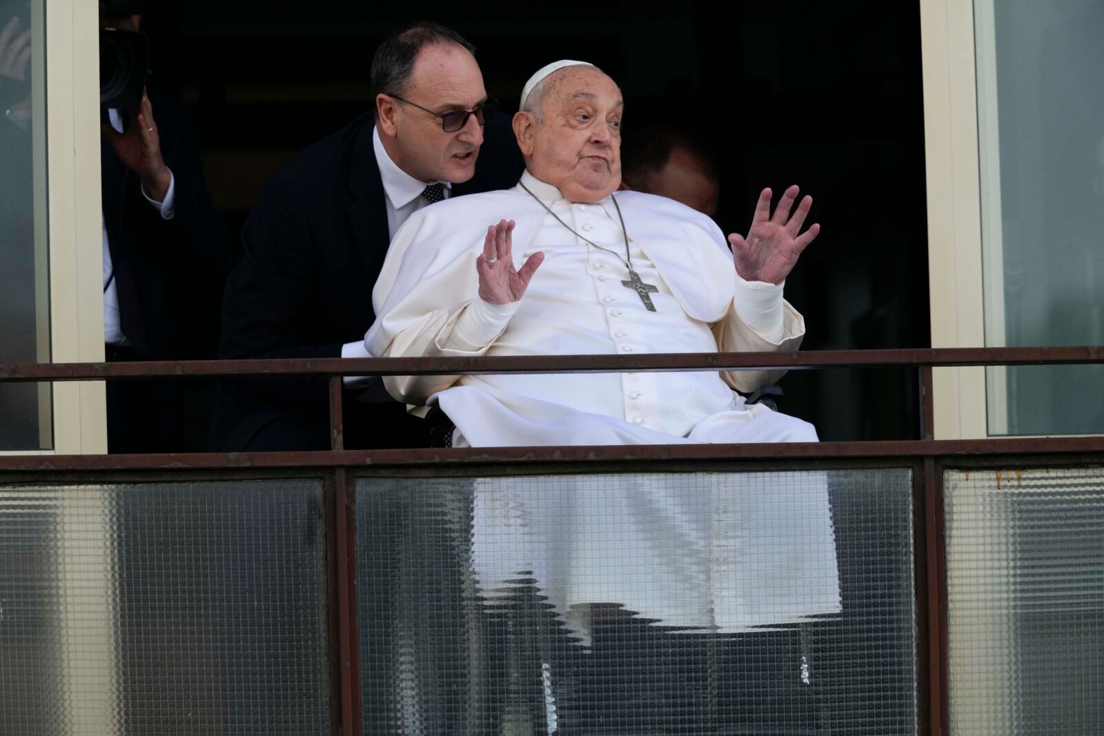 Pope Francis gestures as he appears at a window of the Agostino Gemelli Polyclinic in Rome, Sunday, March 23, 2025, where he has been treated for bronchitis and bilateral pneumonia since Feb. 14. (AP Photo/Domenico Stinellis)