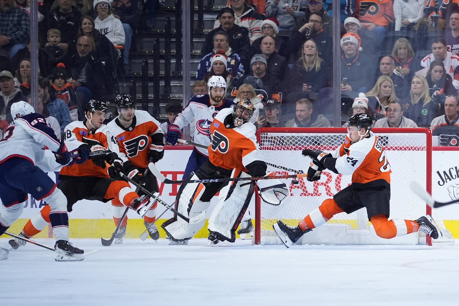 Columbus Blue Jackets' Mikael Pyyhtia (82) scores a goal past Philadelphia Flyers' Nick Seeler (24) and Samuel Ersson (33) during the second period of an NHL hockey game, Saturday, Dec. 21, 2024, in Philadelphia. (AP Photo/Matt Slocum)