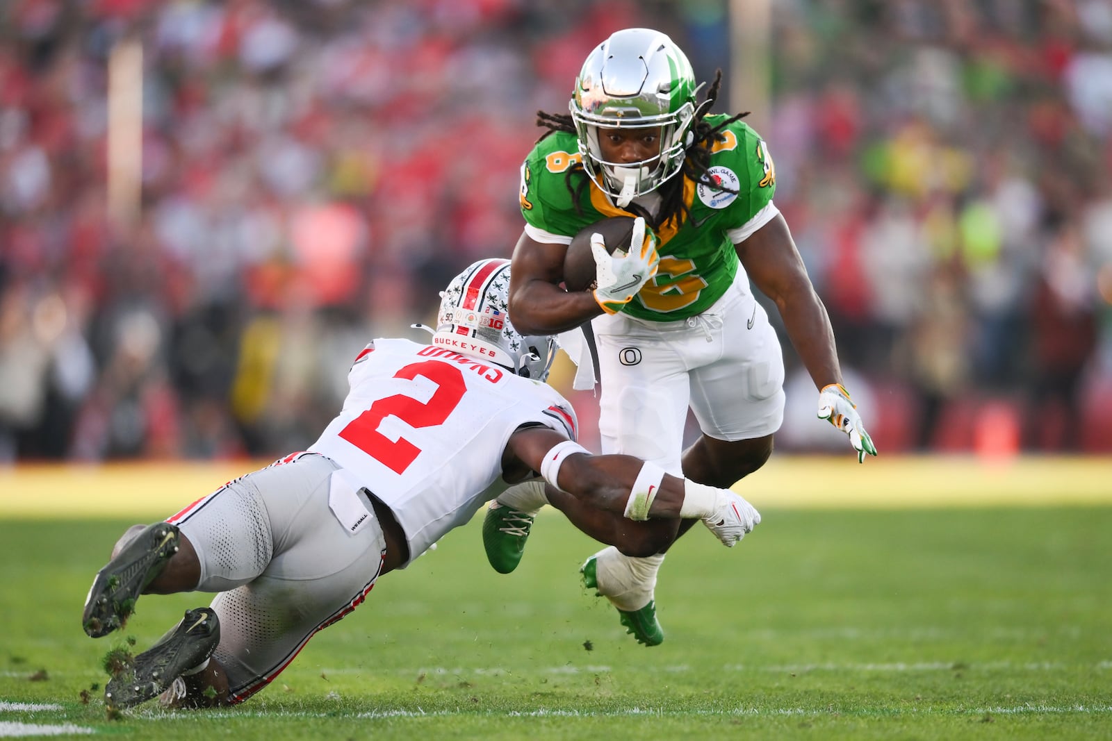 Oregon running back Noah Whittington (6) runs against Ohio State safety Caleb Downs (2) during the first half in the quarterfinals of the Rose Bowl College Football Playoff, Wednesday, Jan. 1, 2025, in Pasadena, Calif. (AP Photo/Kyusung Gong)