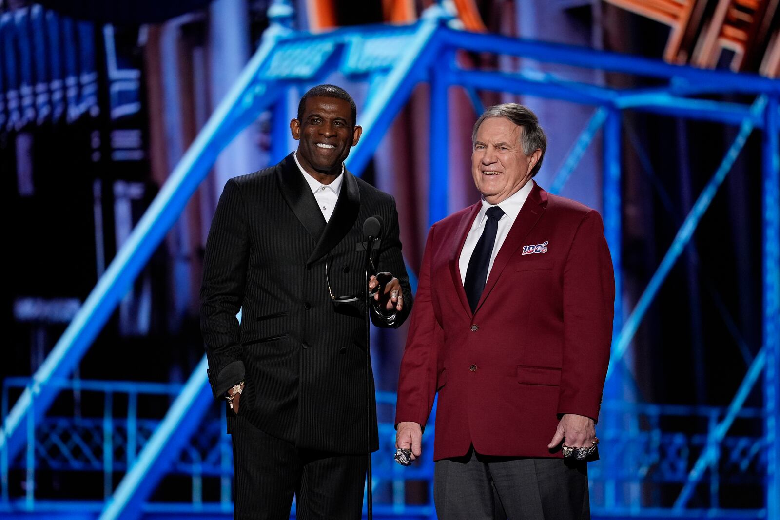 Coaches Deion Sanders, left, and Bill Belichick, right present the Coach of the year award during the NFL Honors award show ahead of the Super Bowl 59 football game, Thursday, Feb. 6, 2025, in New Orleans. (AP Photo/David J. Phillip)