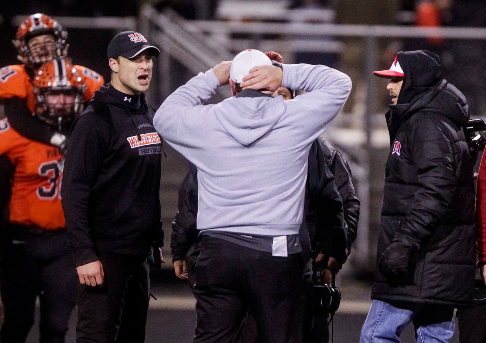 Madison coach Steve Poff (middle) and athletic director Matt Morrison (right) have a heated discussion with Wheelersburg personnel last Saturday night after WHS posted a 24-16 victory in the Division V, Region 20 championship game at Hilliard Darby Stadium. NICK GRAHAM/STAFF