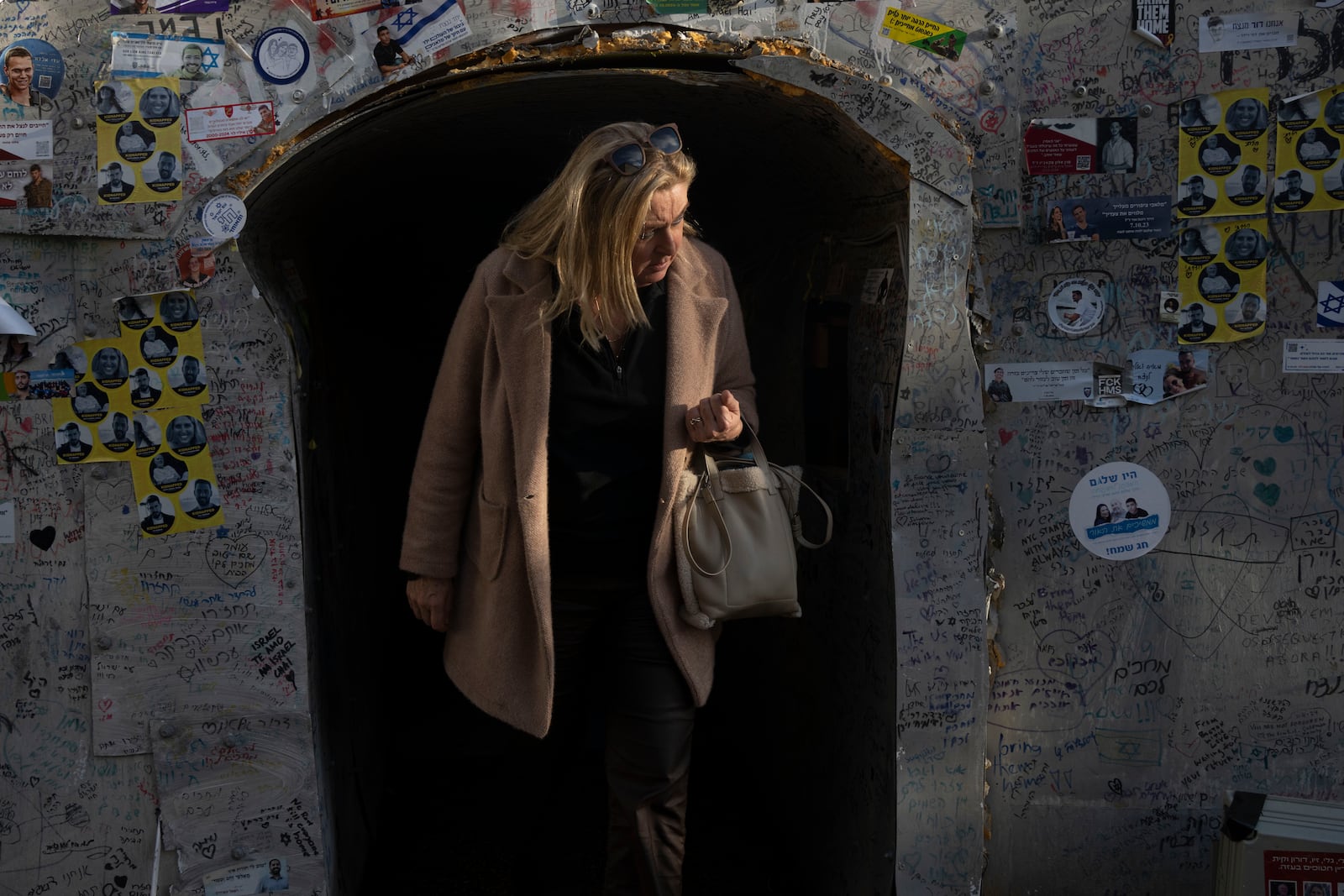 A woman leaves a replica of a tunnel in the Gaza Strip, displayed in solidarity with hostages held by the Hamas militant group in Gaza in Tel Aviv, Israel, Friday, Jan. 24, 2025. (AP Photo/Maya Alleruzzo)