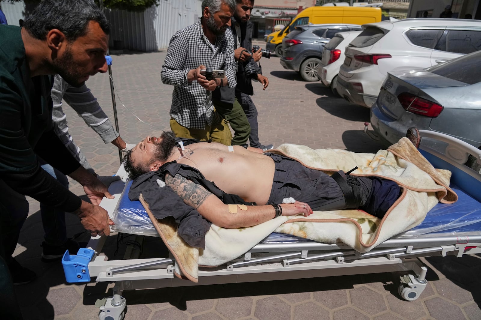 An injured United Nations Mine Action Service (UNMAS) worker is taken into the al-Aqsa Martyrs hospital after an explosion in Deir al-Balah in central Gaza, Wednesday March 19, 2025.(AP Photo/Abdel Kareem Hana)