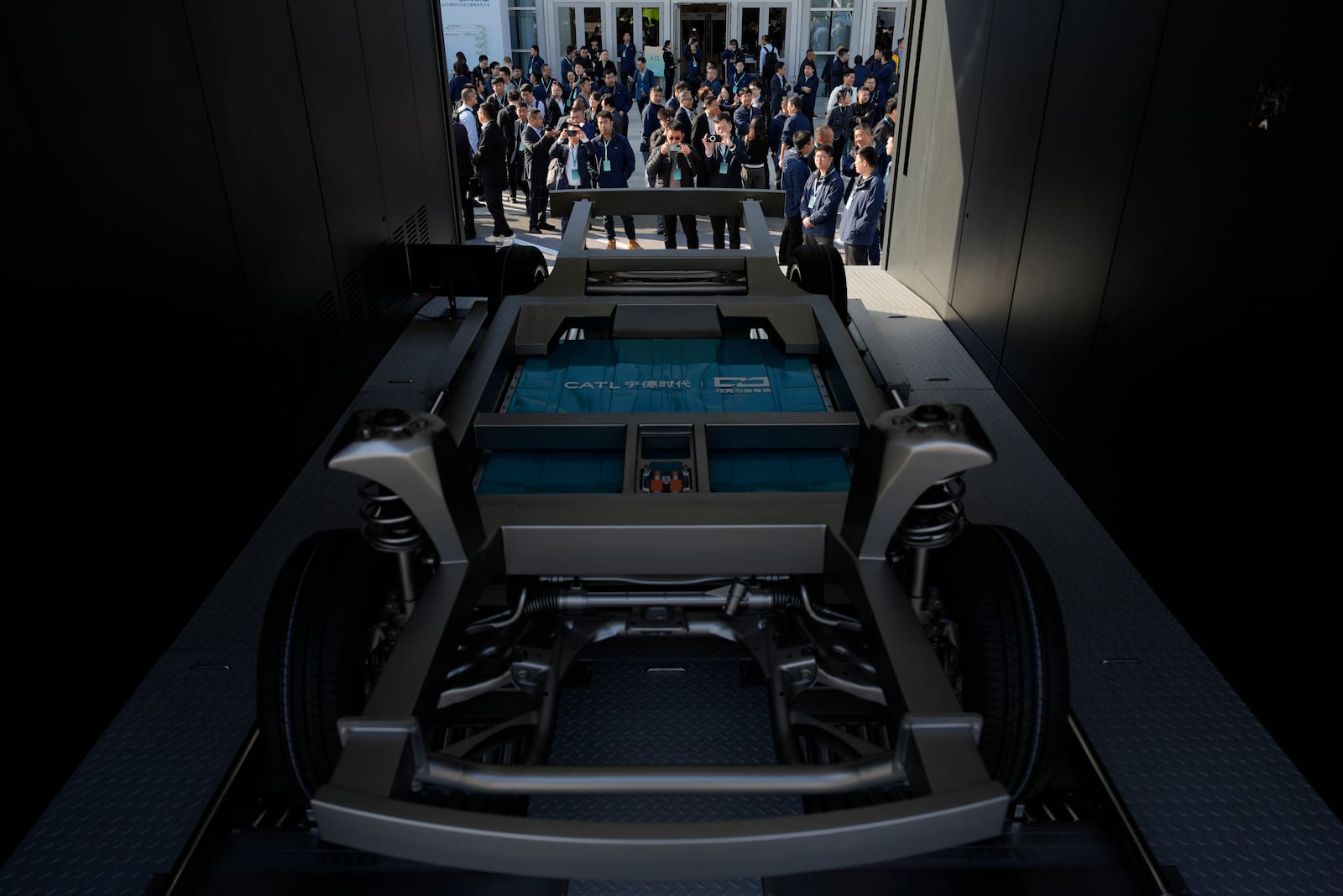 Attendees look at the next generation battery swapping station from China-based CATL, the world's largest maker of batteries for electric vehicles, before a launch presentation held in Xiamen, southern China's Fujian province on Wednesday, Dec. 18, 2024. (AP Photo/Ng Han Guan)