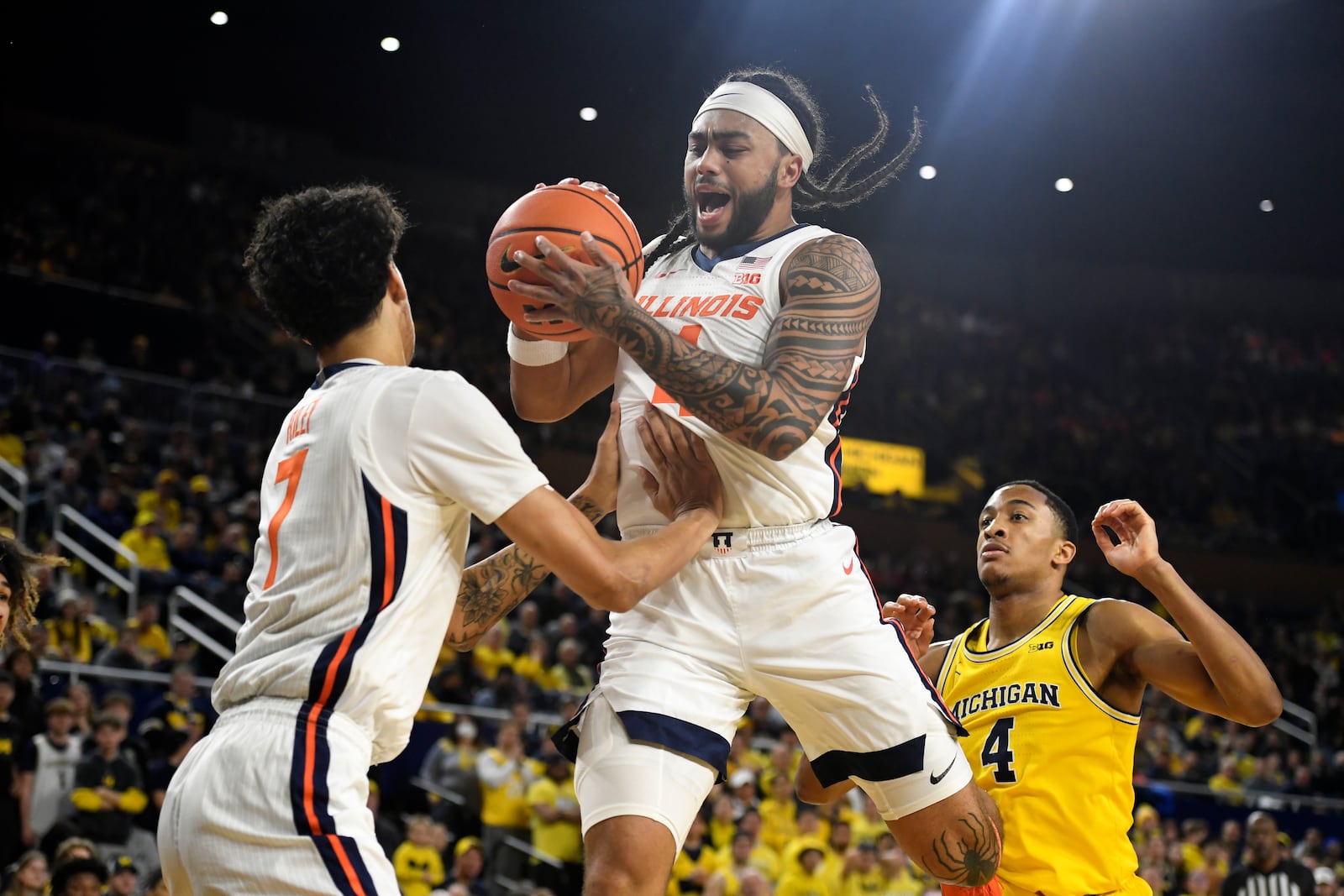 Illinois guard Kylan Boswell, center, grabs a rebound as he crashes into Illinois forward Will Riley, left, during the first half of an NCAA college basketball game against Michigan, Sunday, March 2, 2025, in Ann Arbor, Mich. (AP Photo/Jose Juarez)