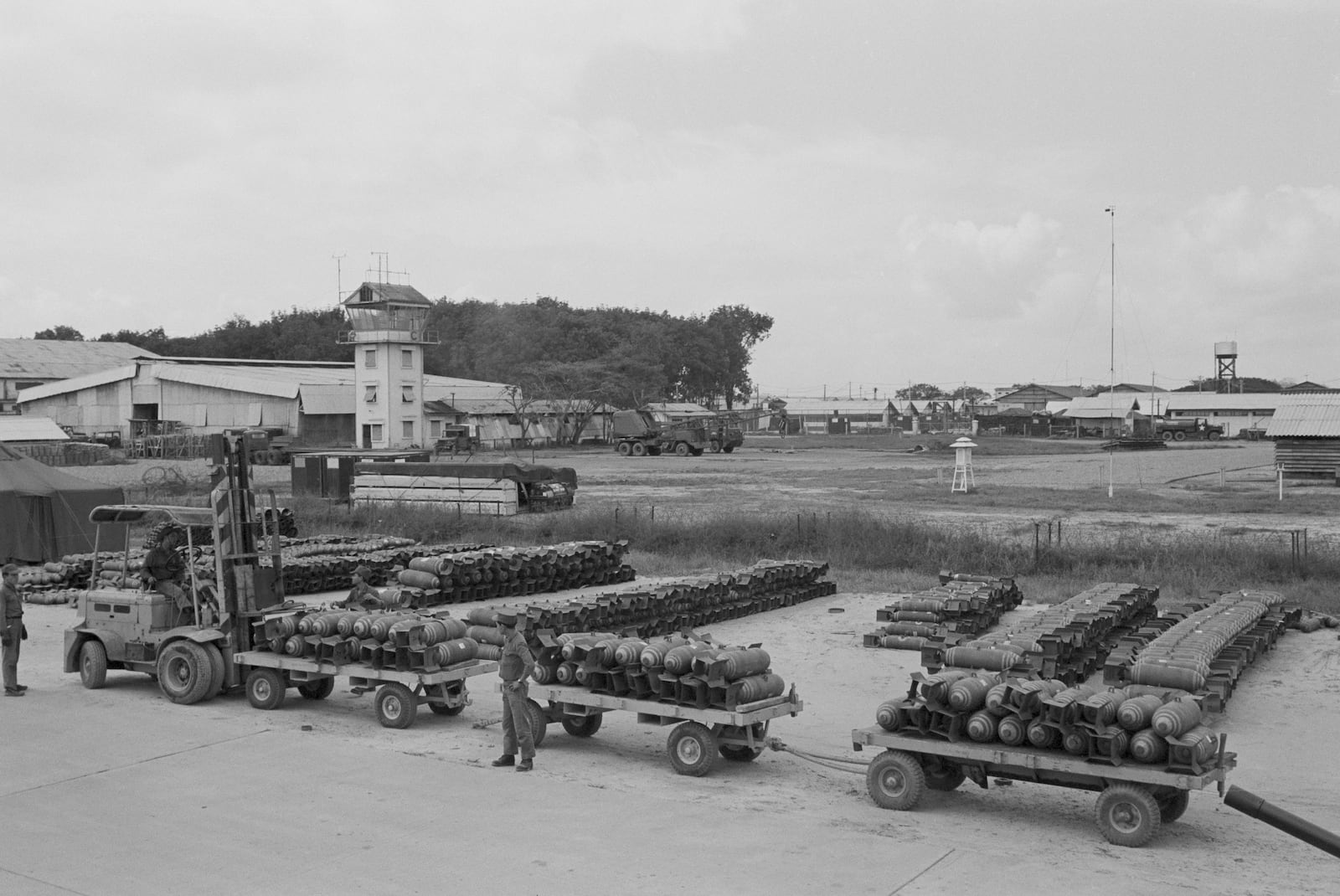 FILE- A detail of South Vietnamese Air Force men load up a tractor-train of 500-pound bombs from the Bien Hoa Air Base ammunition depot, Dec. 29, 1964. (AP Photo/Horst Faas, File)