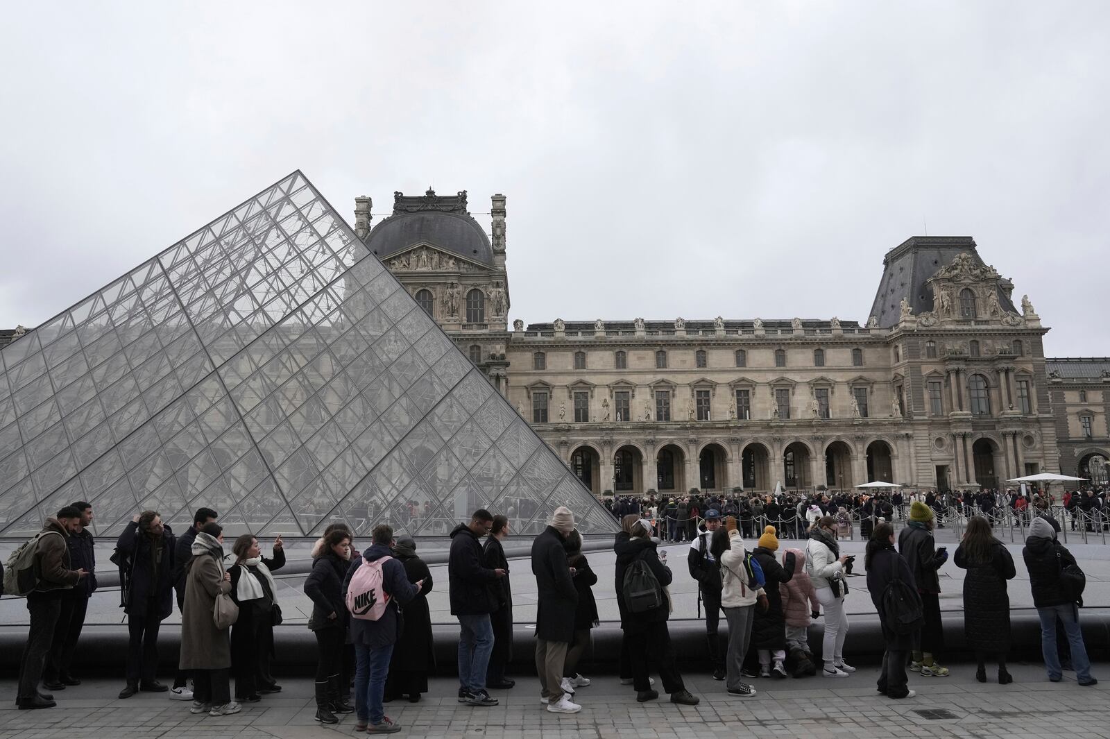 People line up to enter the Louvre museum, Monday, Jan. 27, 2025 in Paris. (AP Photo/Thibault Camus)