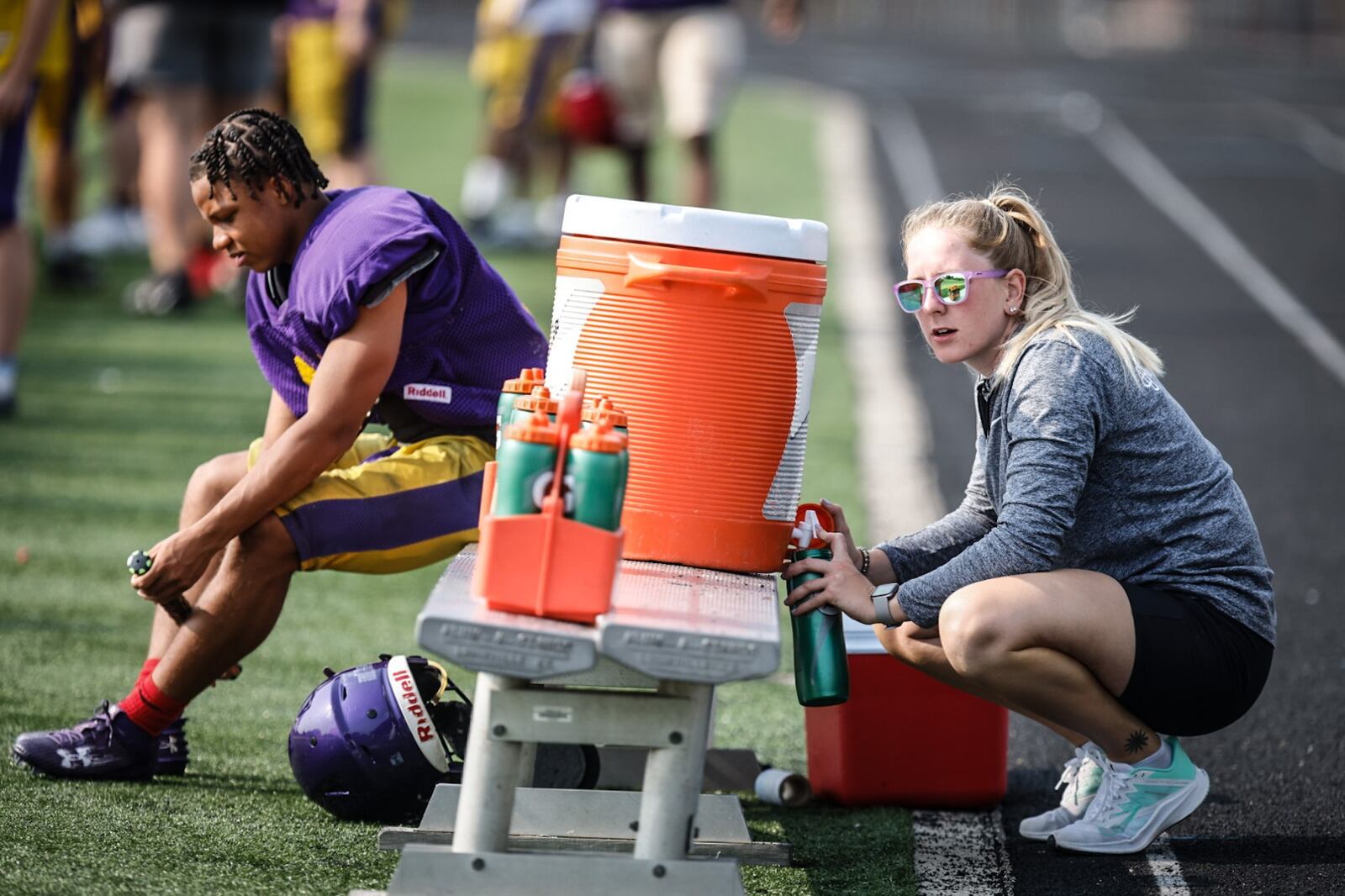 Butler High School football trainer, Samantha Twining fills water bottles on a hot August day at practice. JIM NOELKER/STAFF