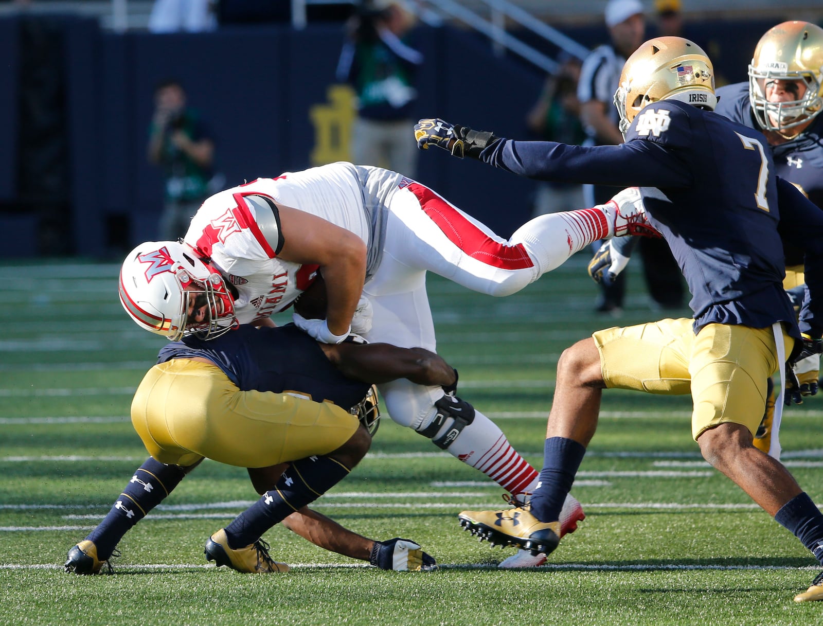 Notre Dame safety Nick Coleman (left), an Alter High School graduate, tackles Miami tight end Ryan Smith during Saturday night’s 52-17 victory by the Fighting Irish at Notre Dame Stadium in Notre Dame, Ind. CHARLES REX ARBOGAST/ASSOCIATED PRESS