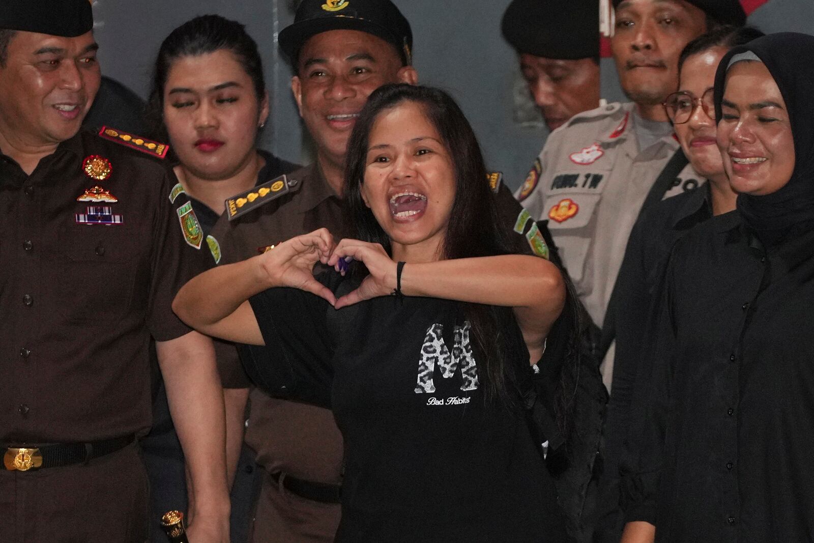 Filipino death row inmate Mary Jane Veloso, center, makes a heart sign as she leaves Pondok Bambu Prison for Soekarno-Hatta International Airport in preparation for her repatriation to the Philippines, in Jakarta, Indonesia, Tuesday, Dec. 17, 2024. (AP Photo/Achmad Ibrahim)