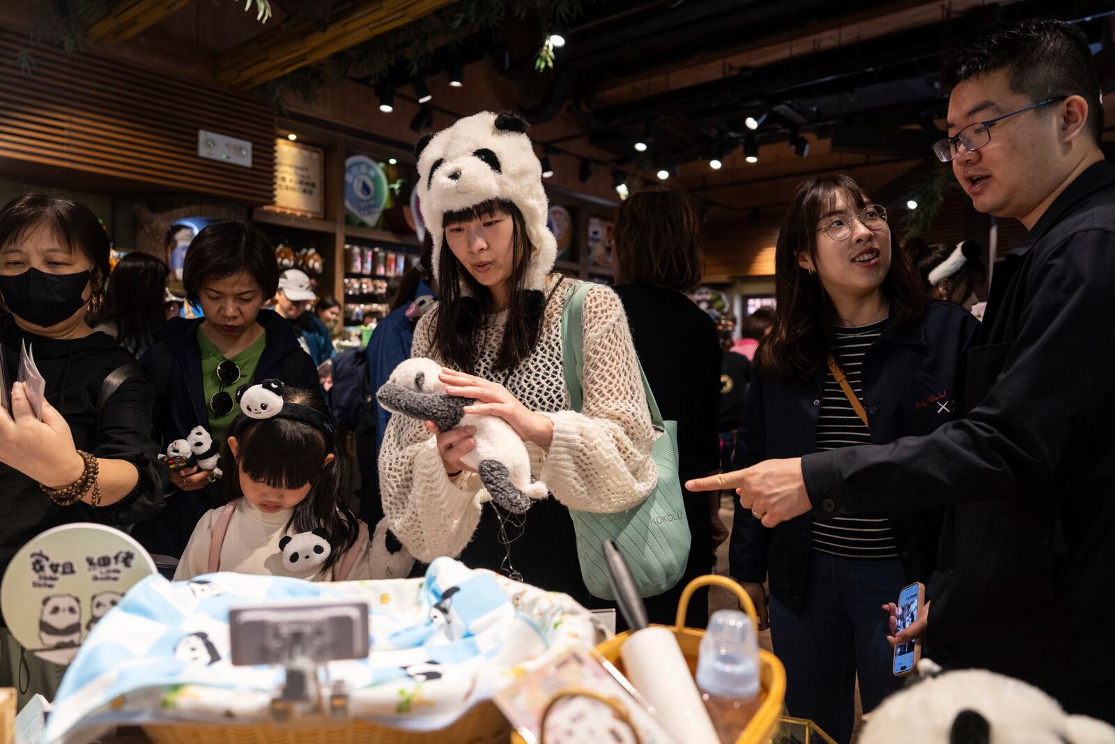 Visitors shop at a panda-themed store in Ocean Park as the Hong Kong-born giant panda twin cubs make their debut appearance to public in Hong Kong, Sunday, Feb. 16, 2025. (AP Photo/Chan Long Hei)