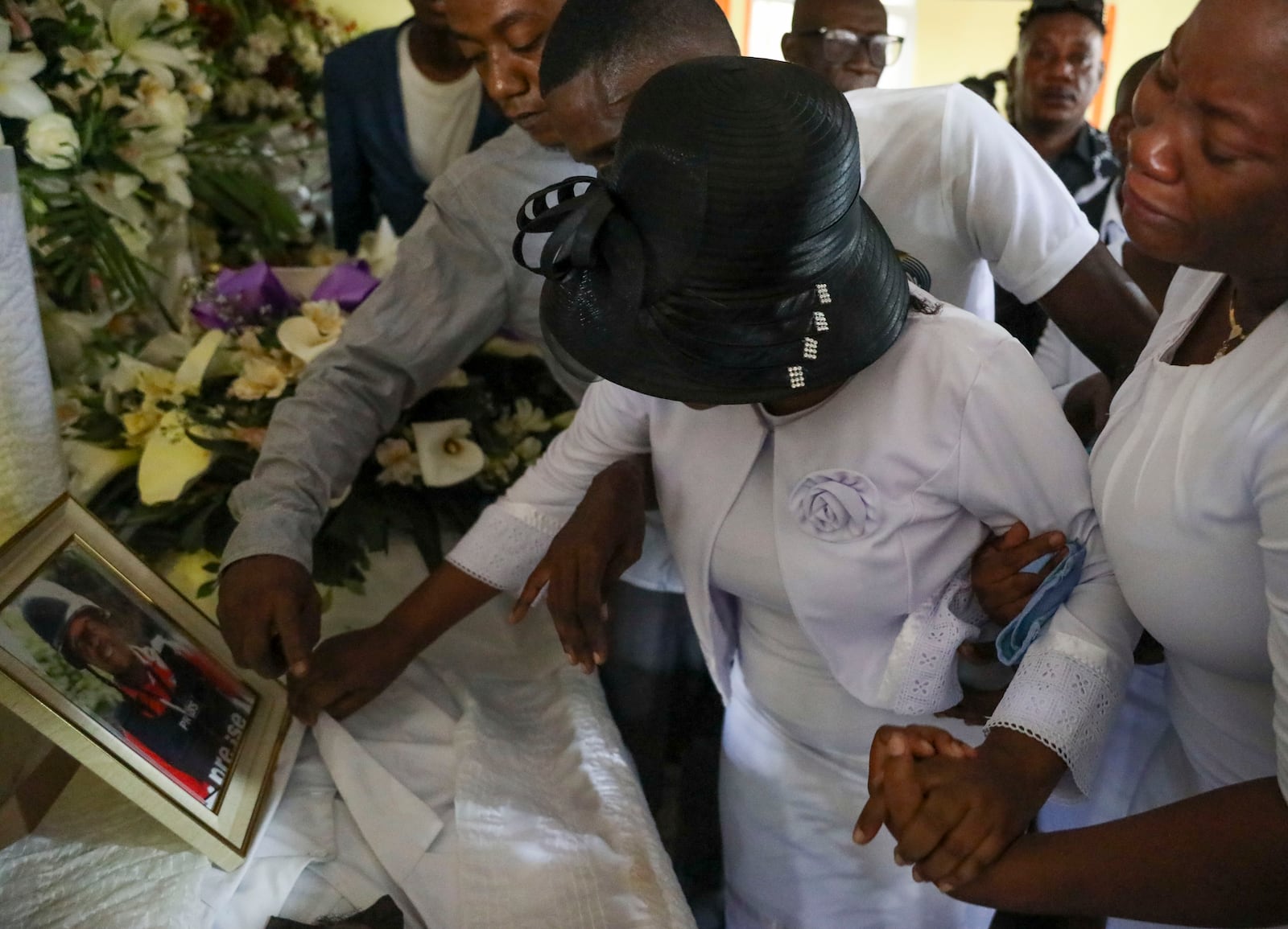 Relatives pay their final respects to journalist Marckendy Natoux, who was killed by gang members on Christmas Eve while covering the reopening of a hospital, during his church funeral service in Port-au-Prince, Haiti, Saturday, Jan. 18, 2025. (AP Photo/Odelyn Joseph)