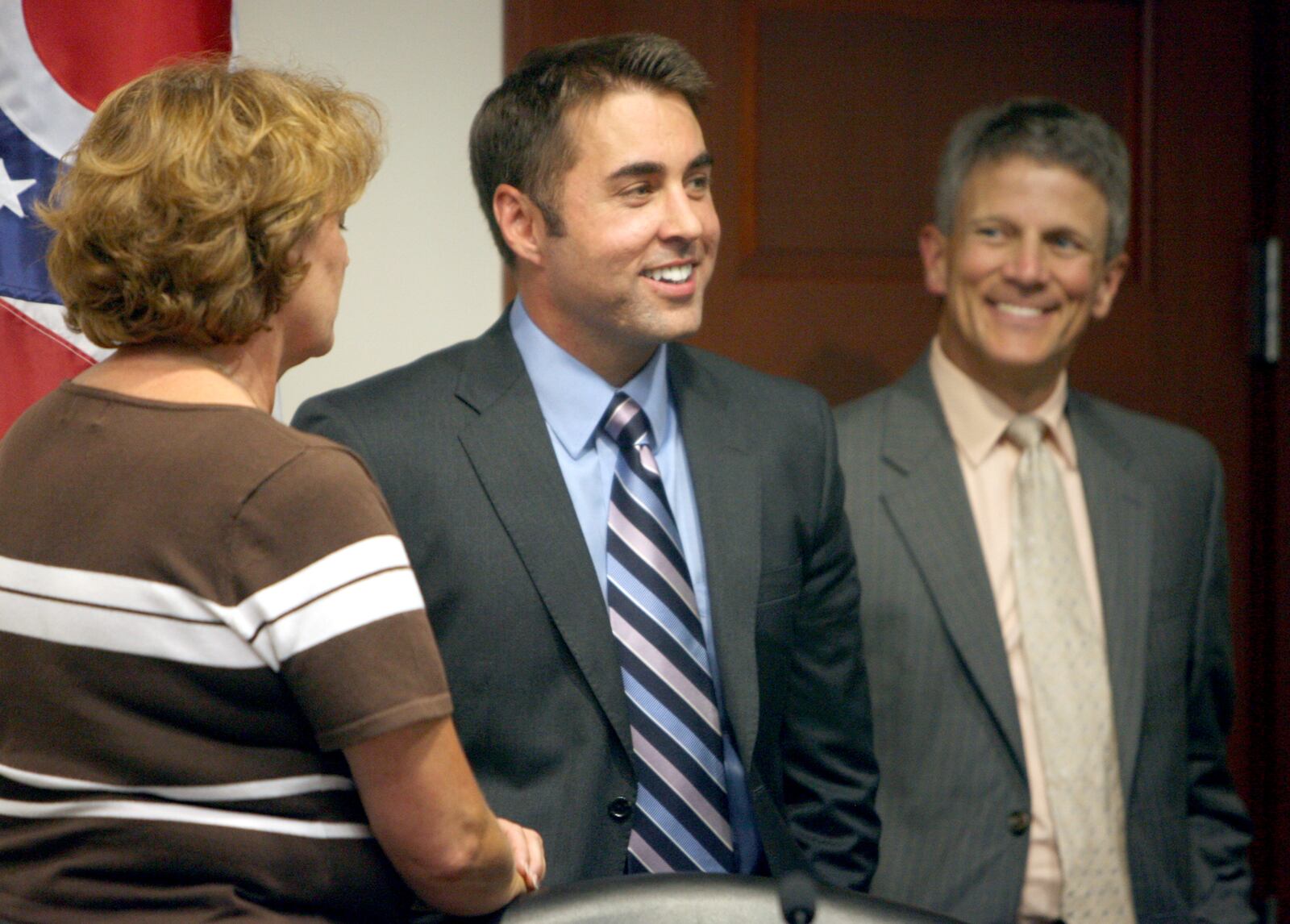 FILE PHOTO: Hamilton City Council members, including Carla Fiehrer and Vice Mayor Rob Wile, greet Joshua A. Smith, center, as its new city manager after a vote in council chambers in July 2010. He started his job in September 2010. 